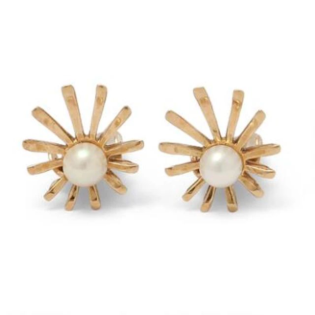 A pair of ear clips each set with a pearl, mounted in 14k gold. Weight