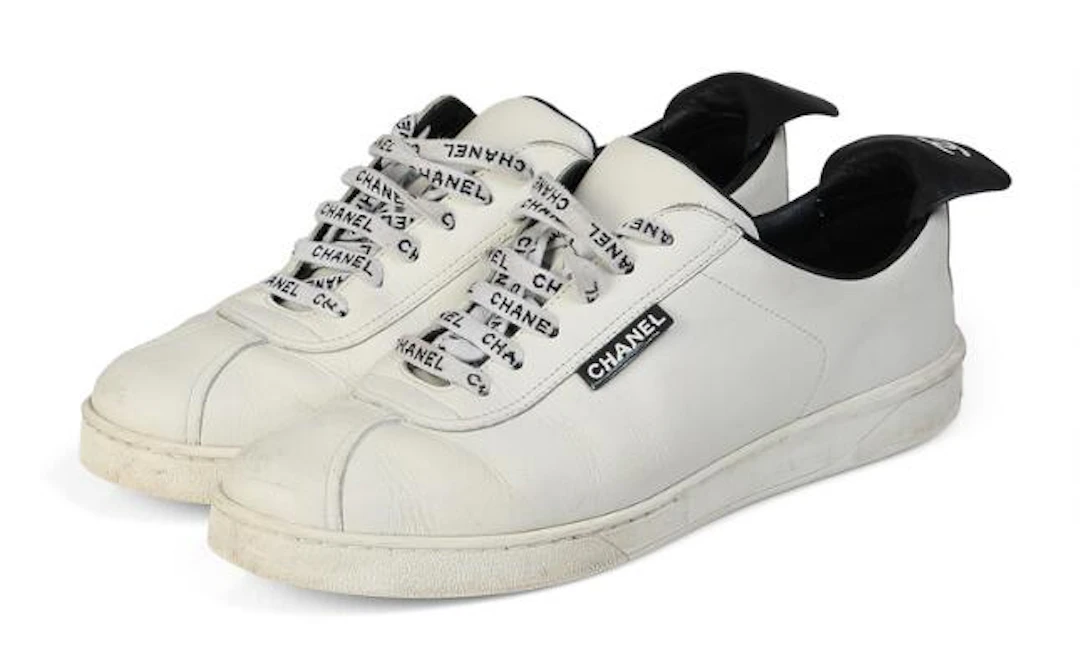 Chanel: A pair of sneakers of white and black leather with logo. Size