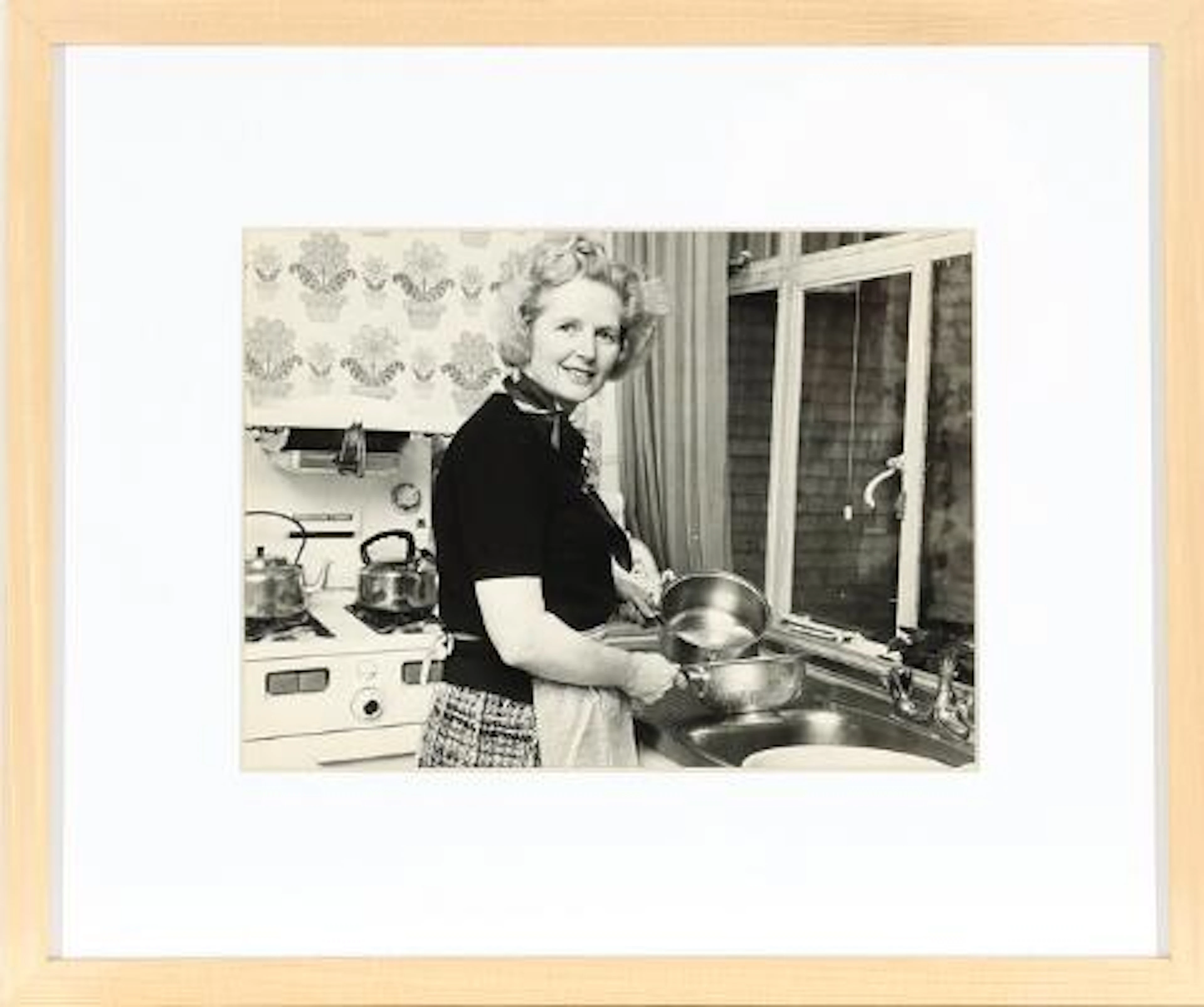 Margaret Thatcher at the kitchen sink. Black-and-white press photograph