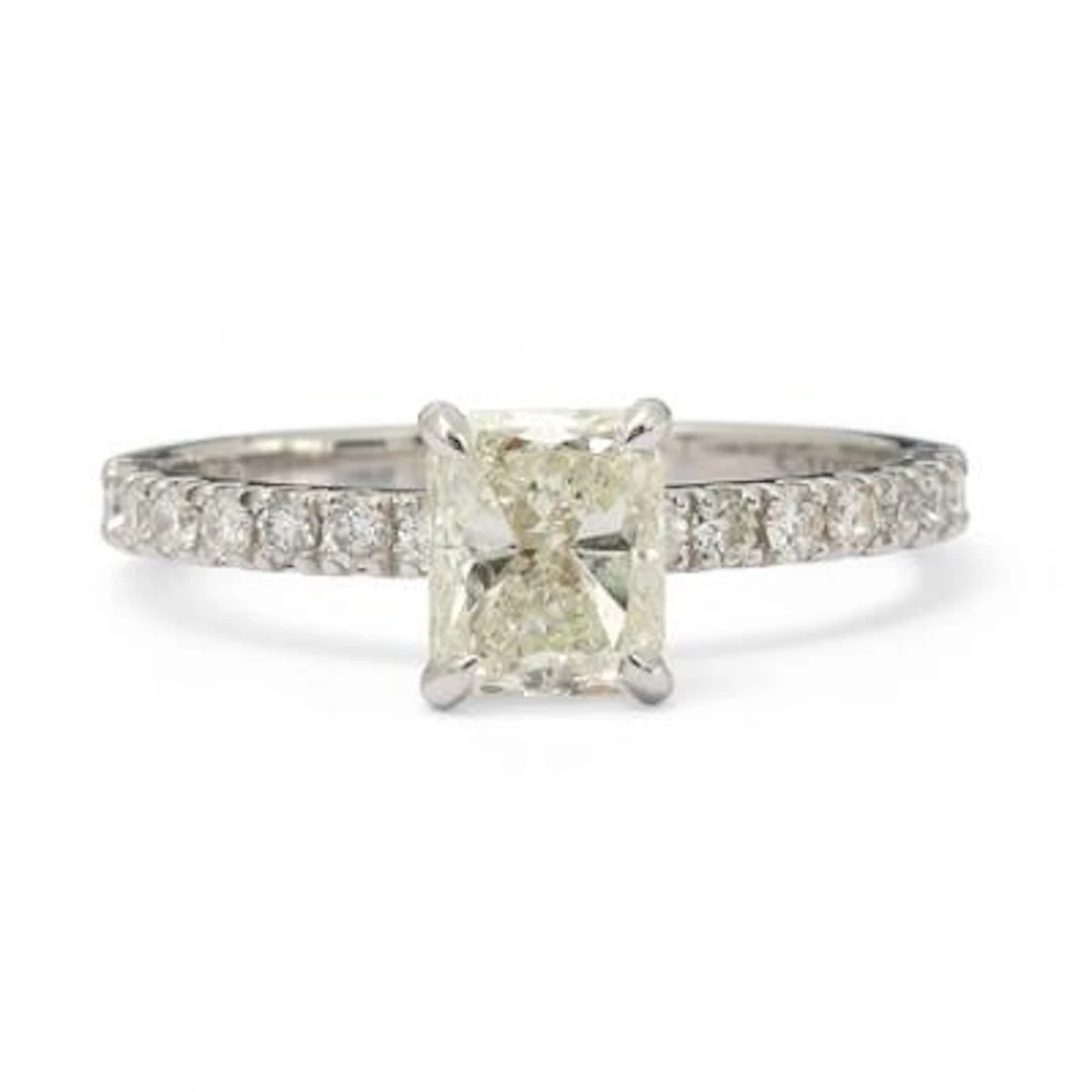 A diamond ring set with an emerald-cut diamond flanked by diamonds