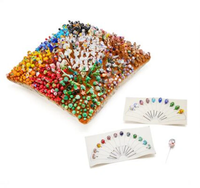 Collection of glass pins mounted on a large cushion (30 x 30), also