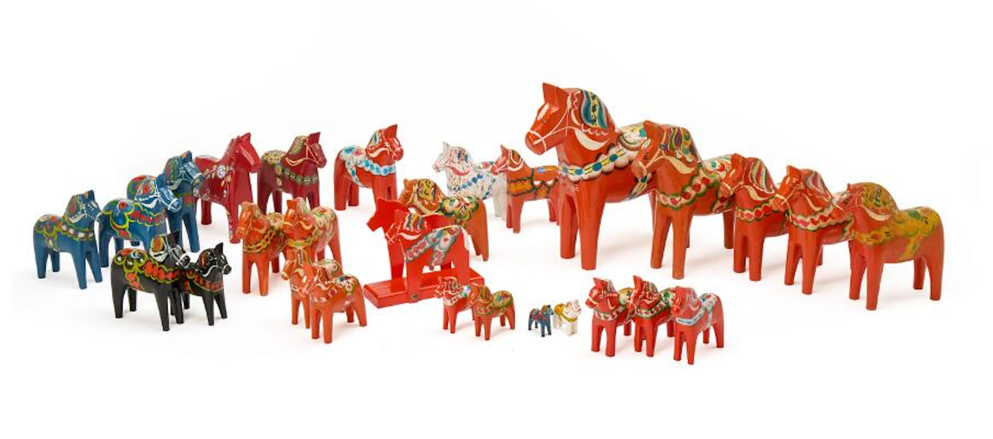 A collection of Dala horses and a napkin holder made of wood, decorated