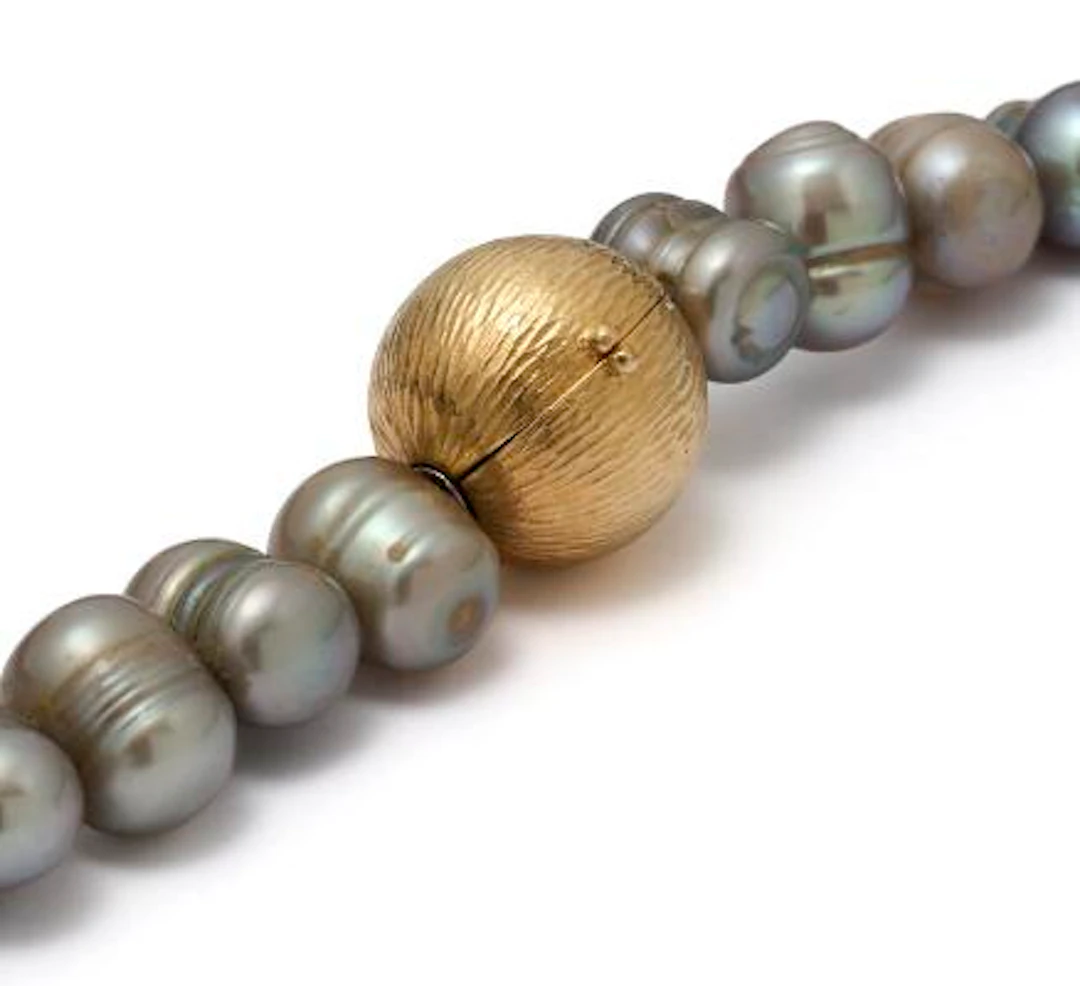 Ole Lynggaard: A globe clasp of 18k gold. And two necklaces with pearls
