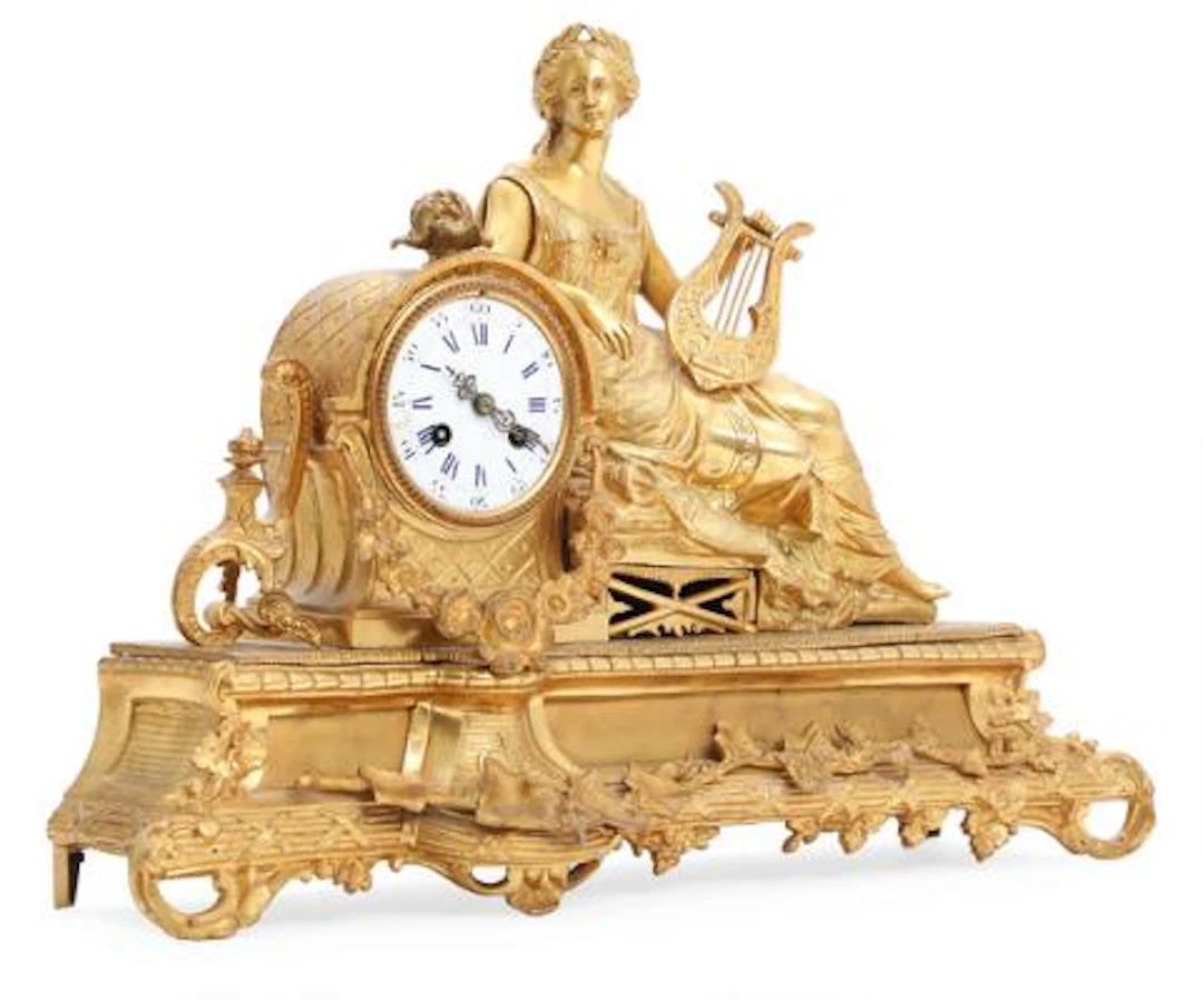 French mantel clock of gilded bronze, on the clock case a seated woman