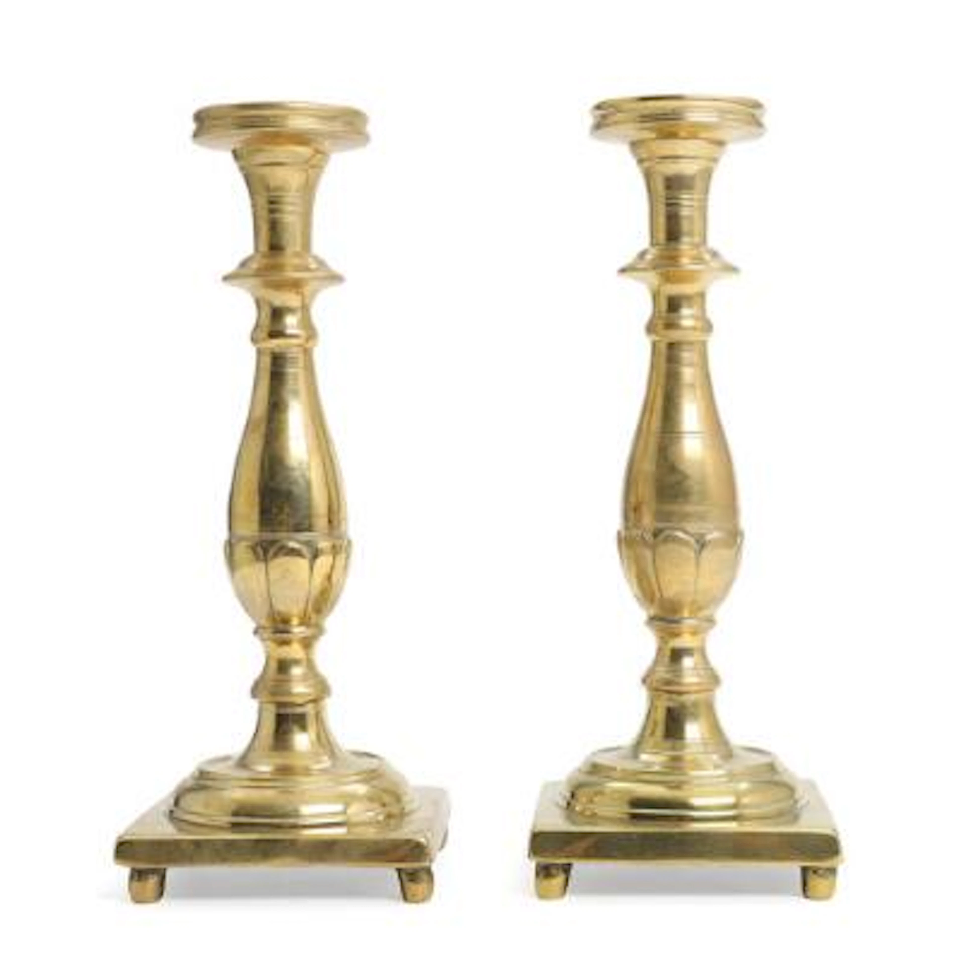 A pair of almost identical Baroque brass candlesticks with baluster-form