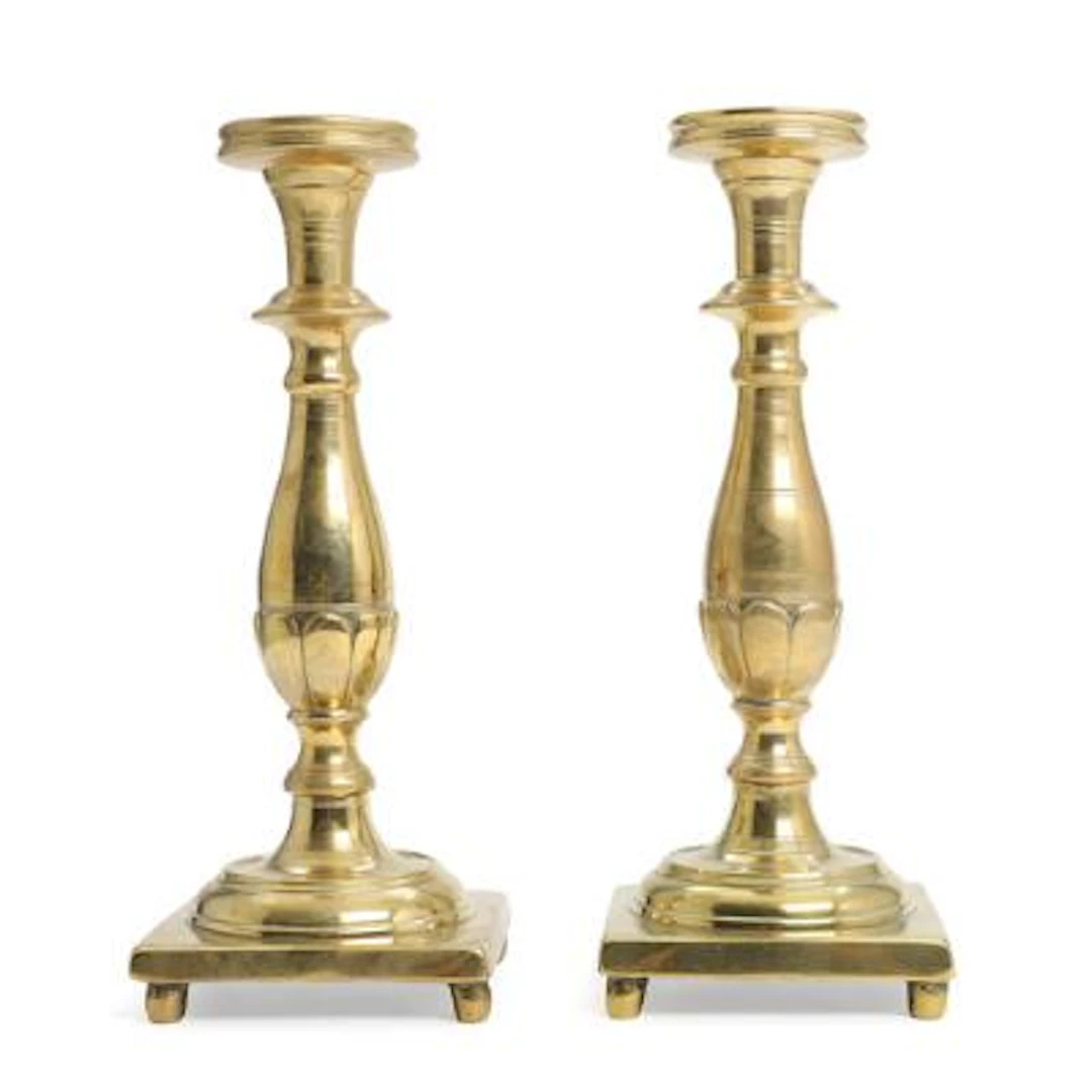 A pair of almost identical Baroque brass candlesticks with baluster-form
