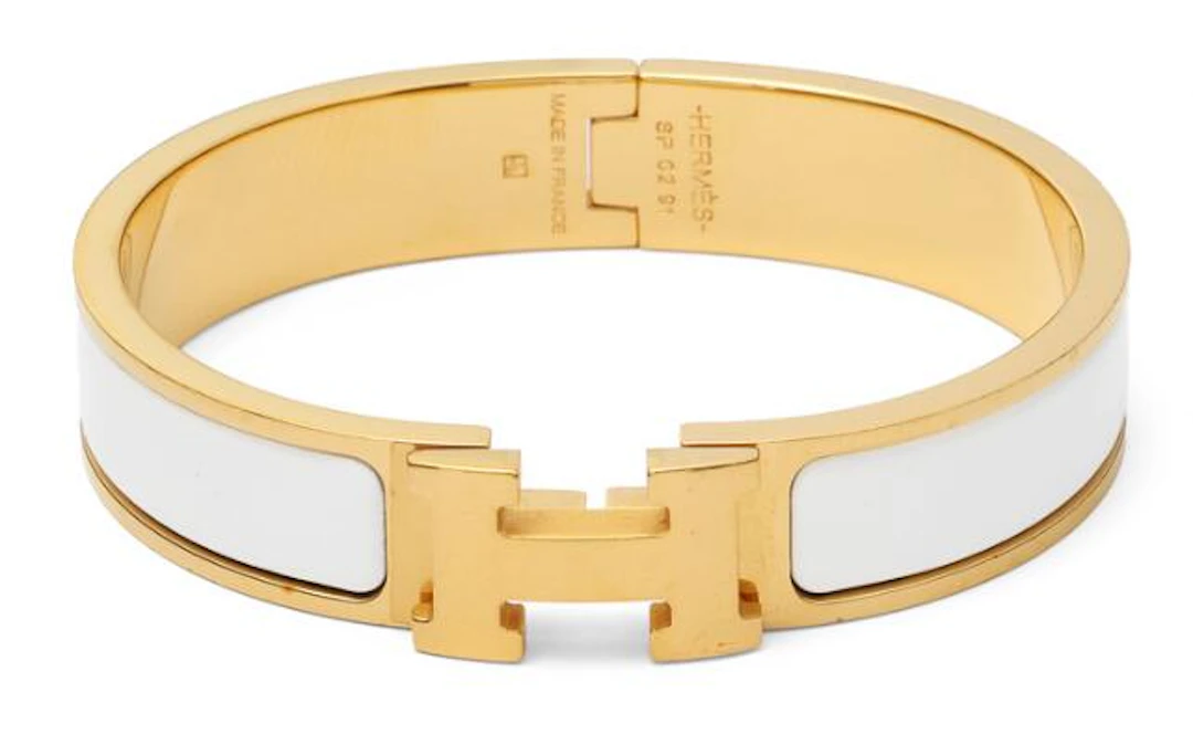 Hermès: A "Clic H" bangle of gilded metal and white enamel. Weight