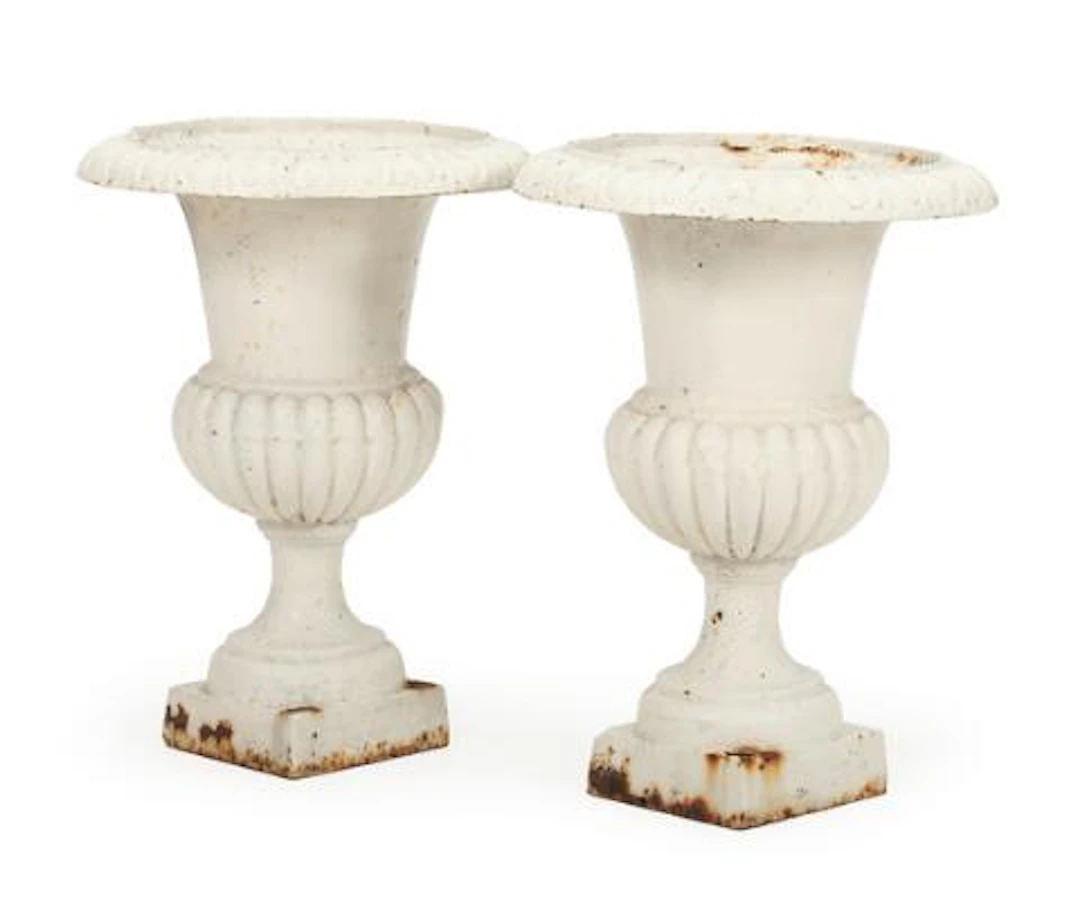 A pair of white-painted cast iron garden vases, decorated with ornamental