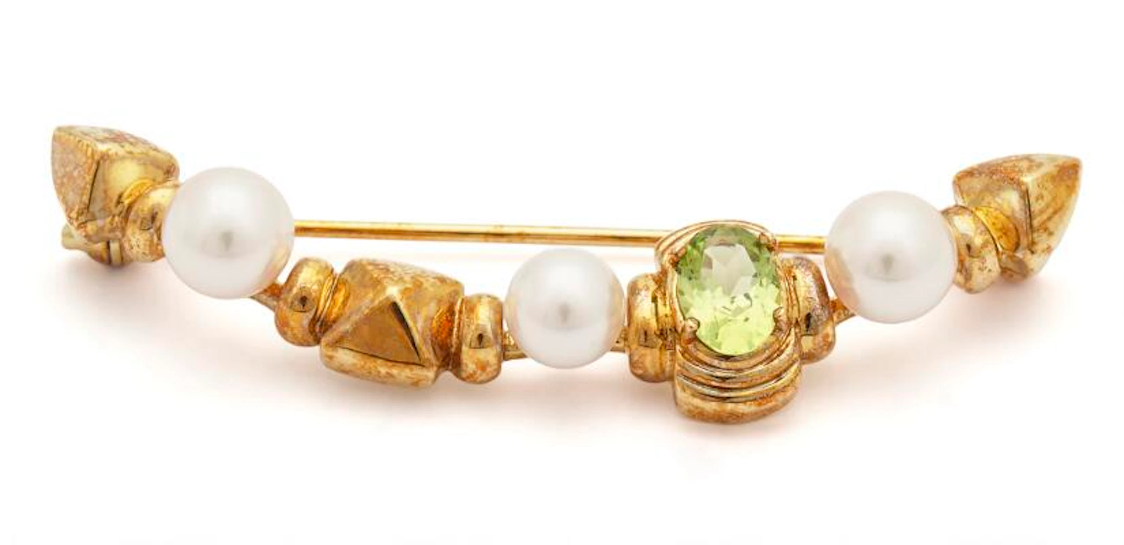 Mikimoto: A peridote and pearl brooch set with a peridote and three