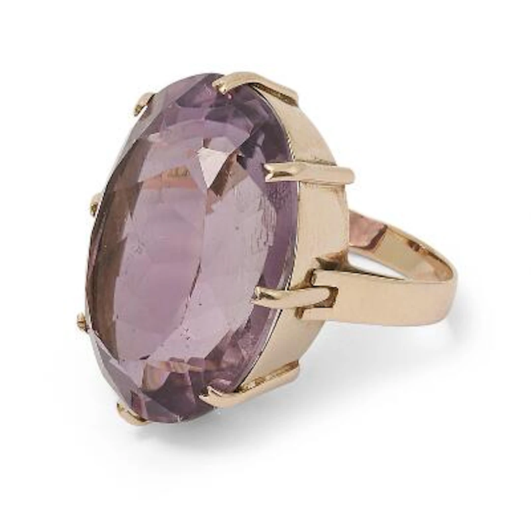 An amethyst ring set with an oval-cut amethyst mounted in 14k gold.