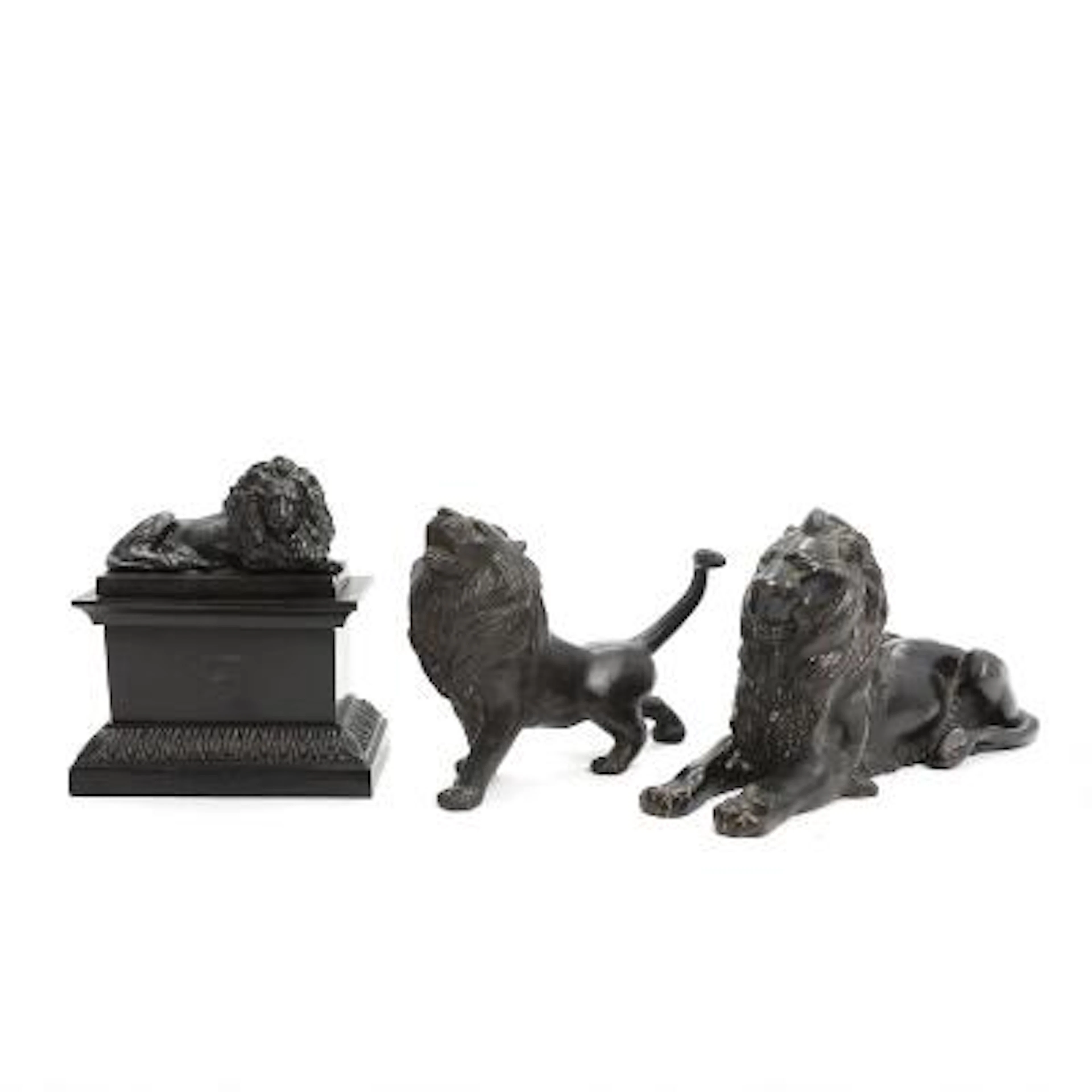 Two figurines and inkwell of patinated bronze in the form of lions.