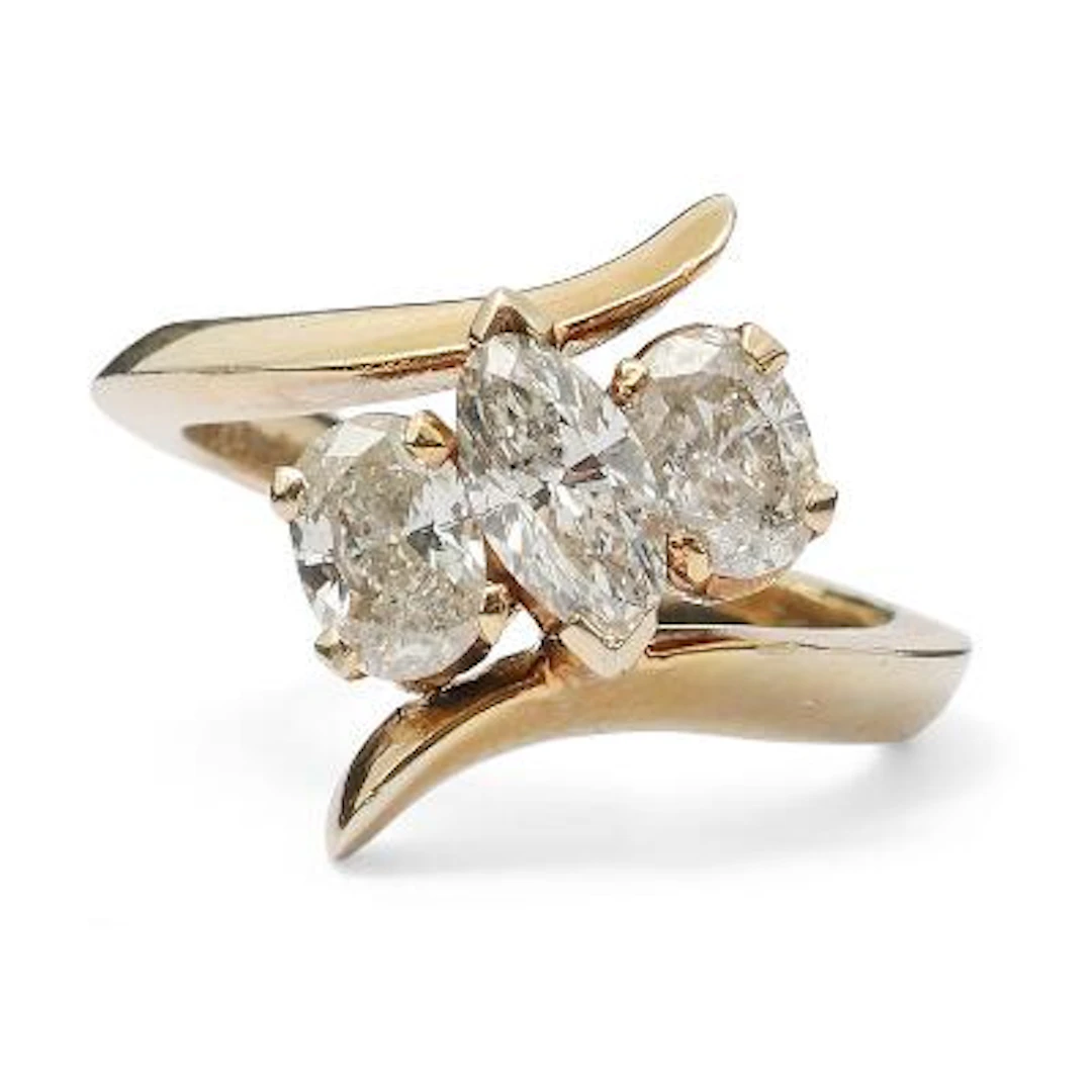 A diamond ring set with a marquise-cut and two oval-cut diamonds