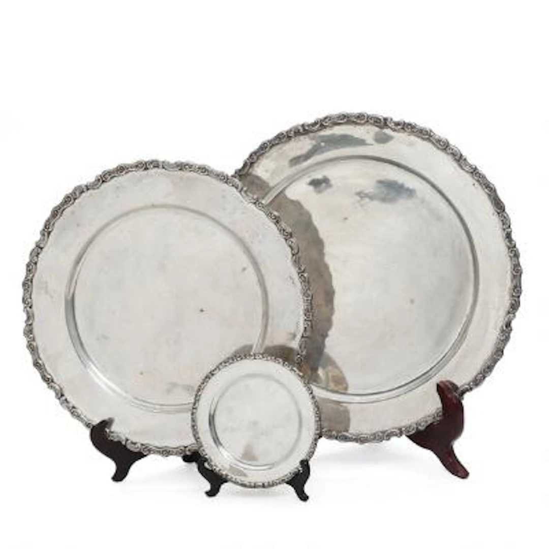 Peruvian silverware comprising two trays and a bottle coaster of sterling