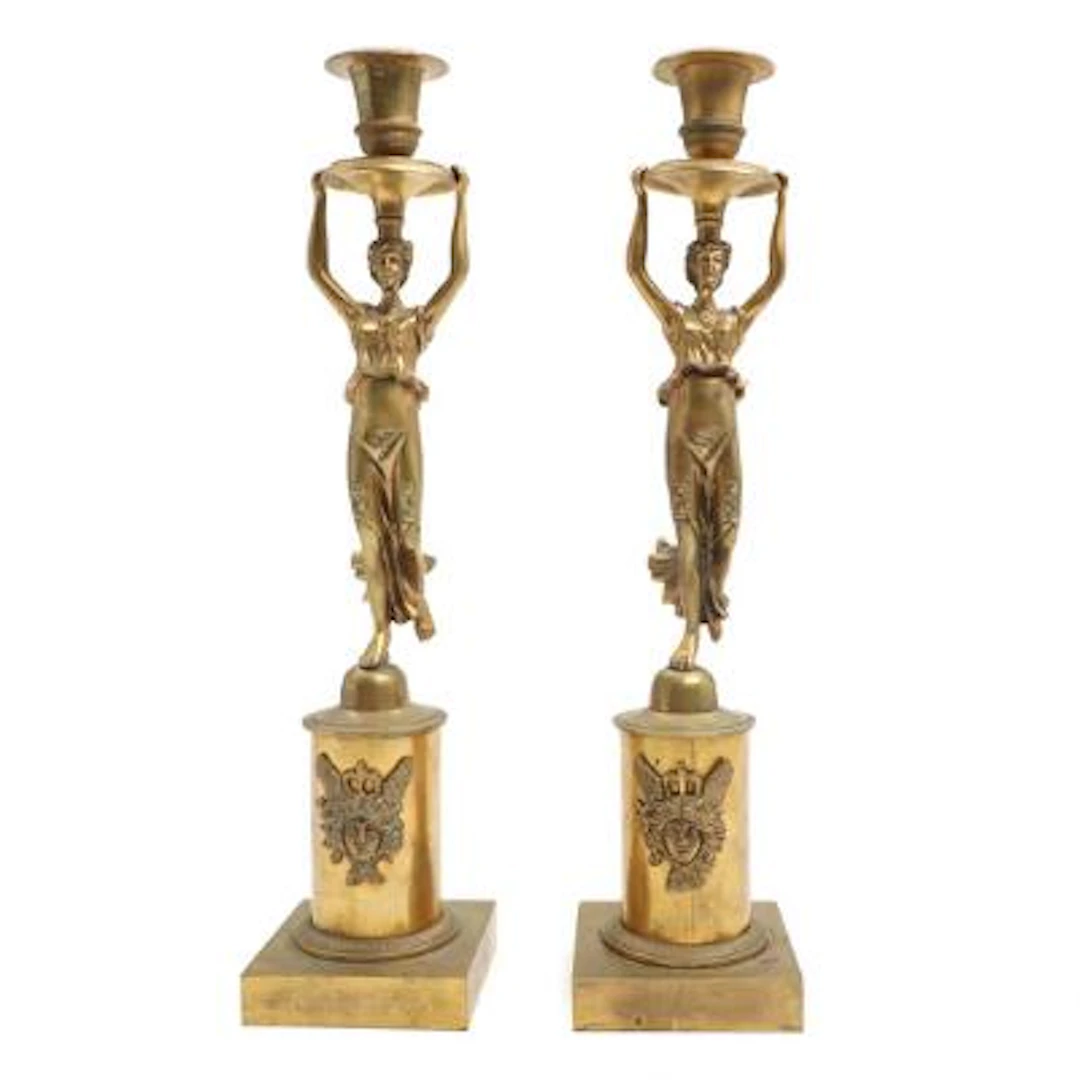 A pair of bronze candlesticks, the stem in the form of a female figure.