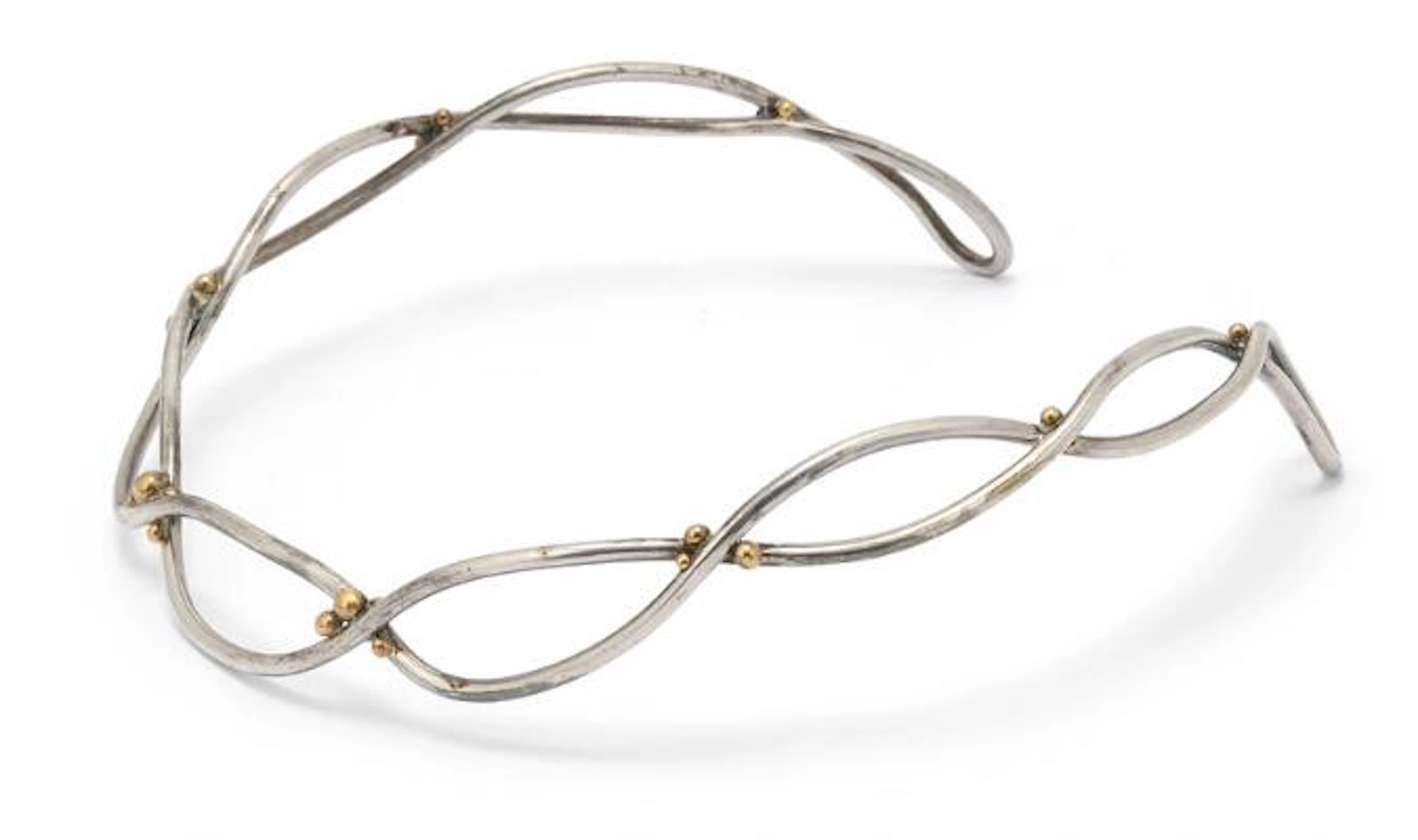 A neckring of sterling silver set with links of 14k gold. Weight app.