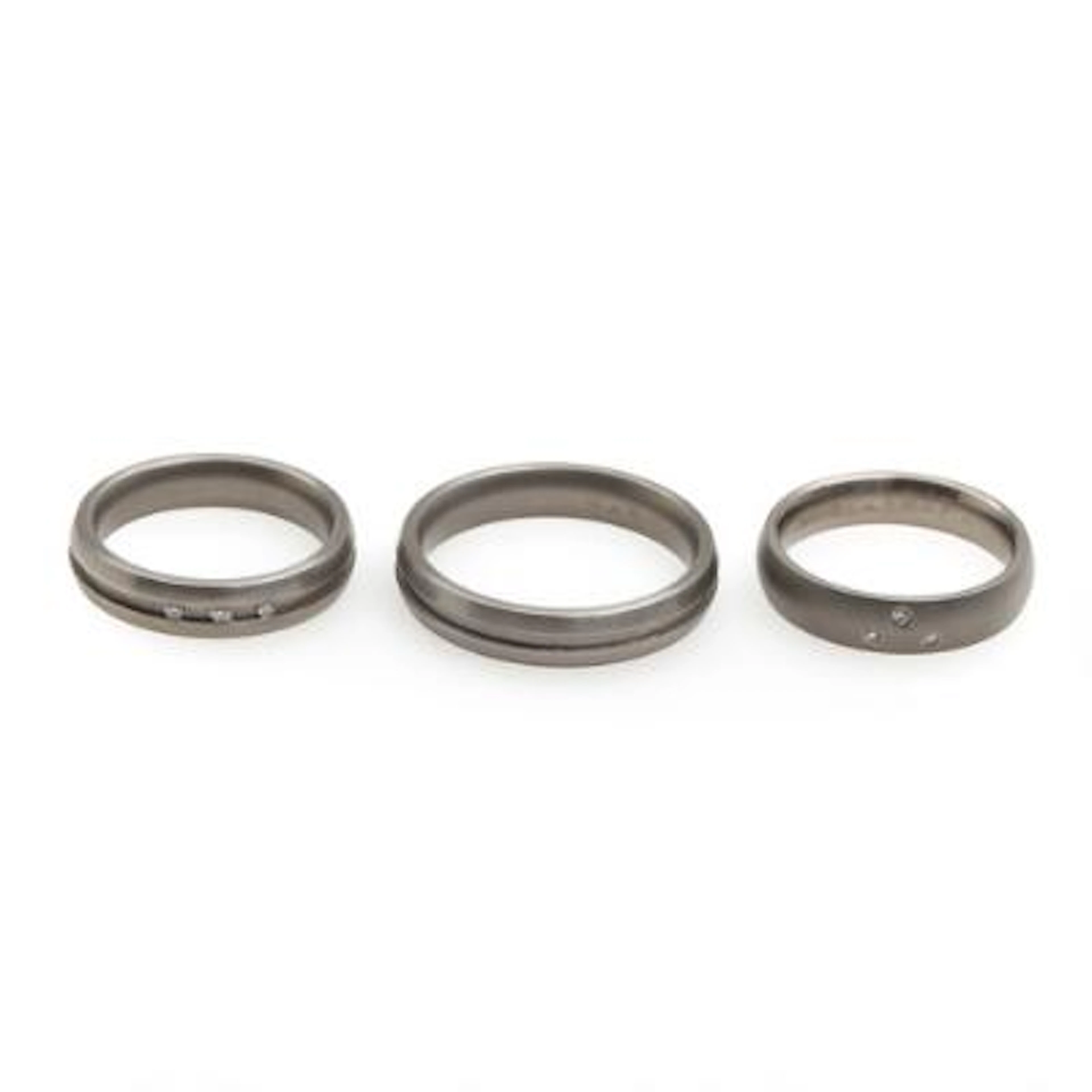 Three rings, the two set with brilliant-cut diamonds, mounted in titanium.