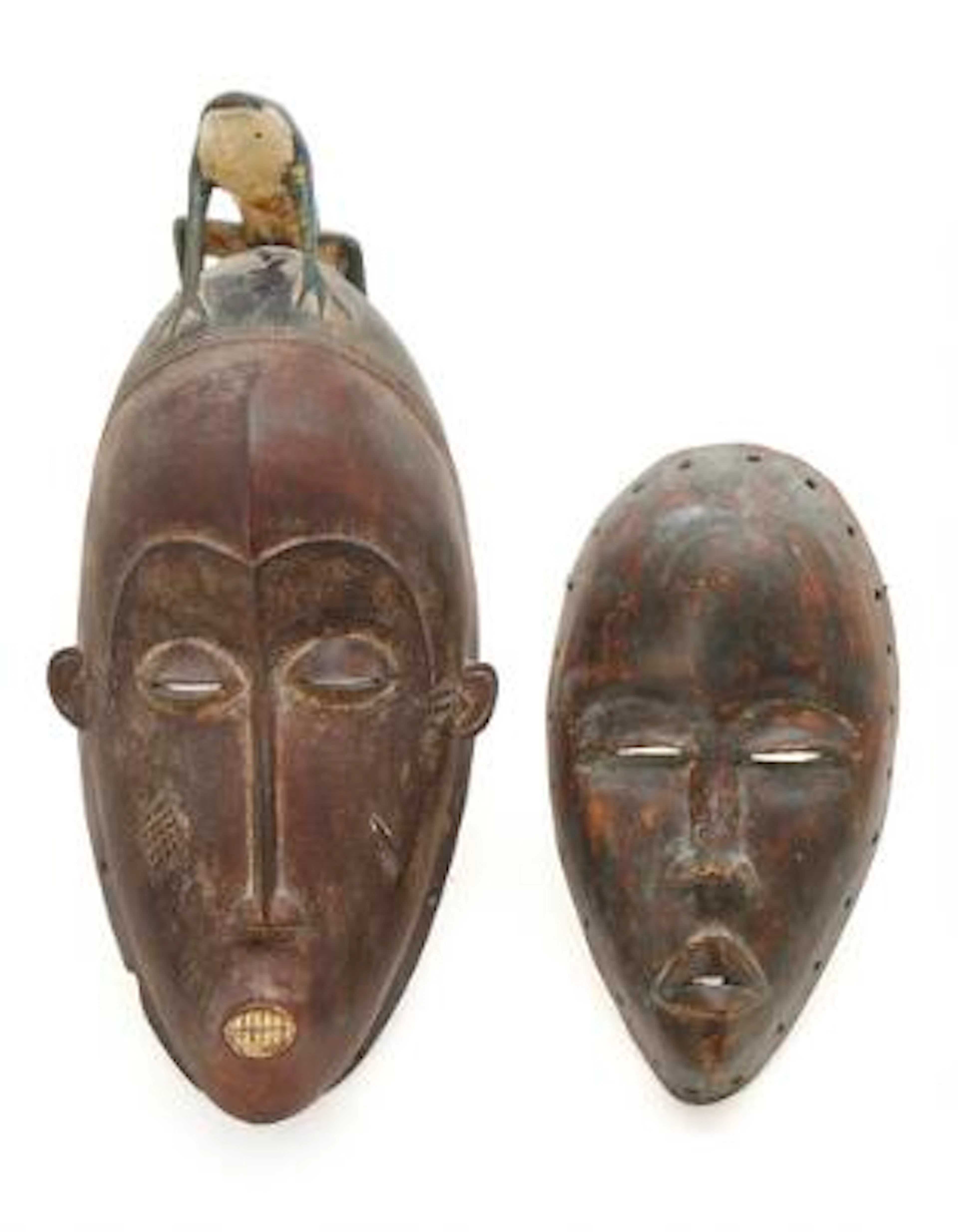 Two masks of carved patinated wood. Baoule and Dan style. H. 41 cm.