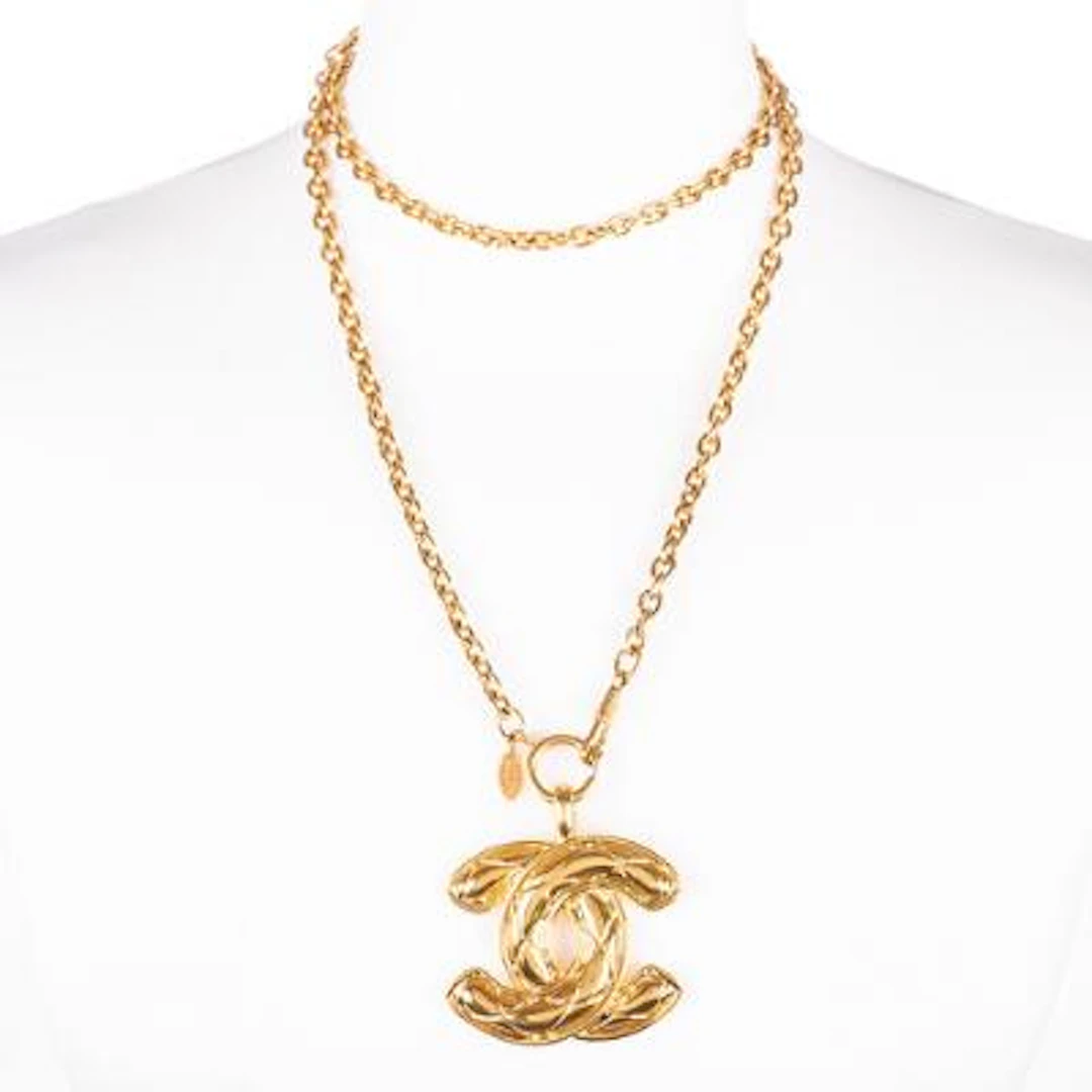 Chanel: Necklace in gold-toned metal set with a CC pendant. L. 46