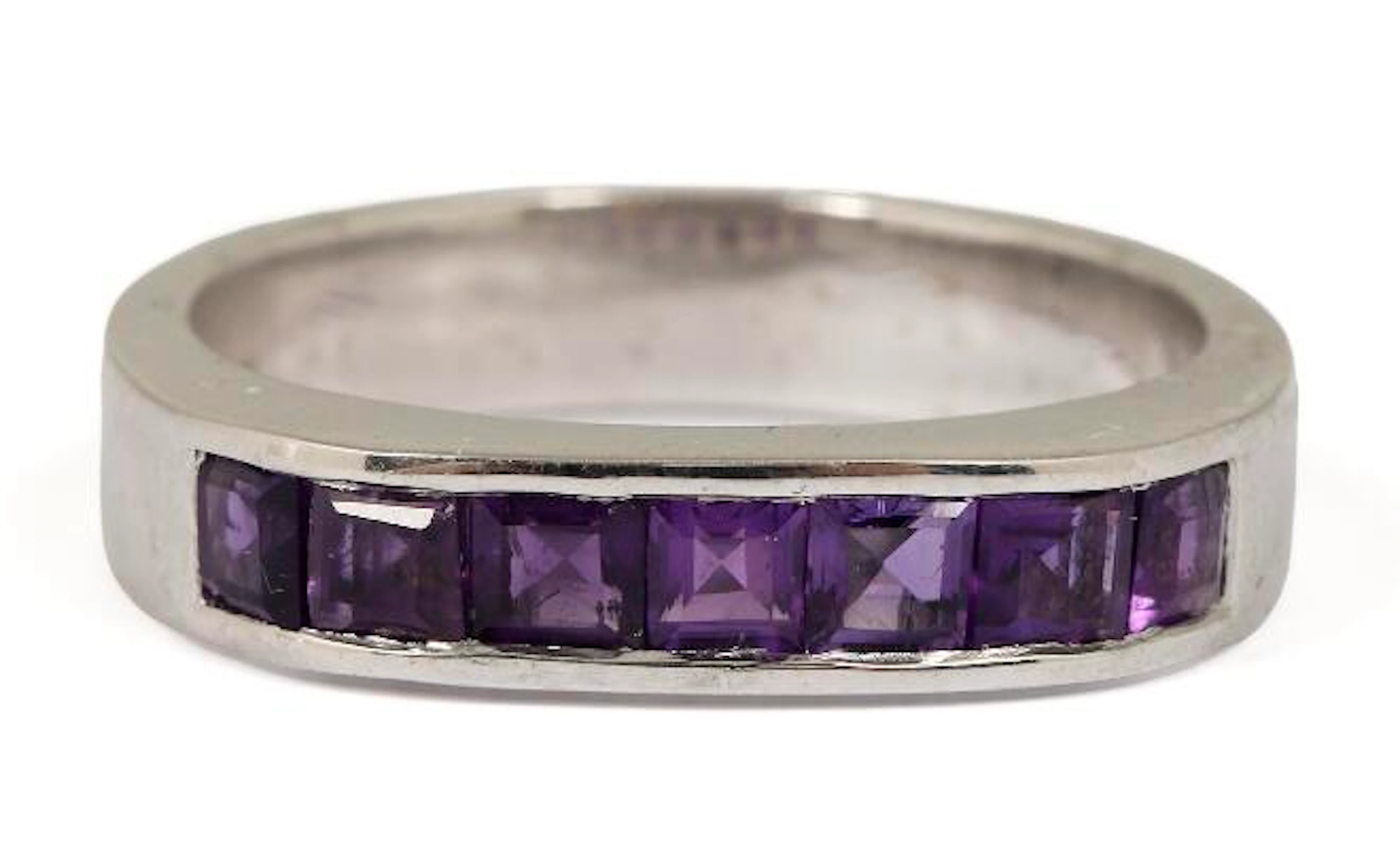 An amethyst ring set with seven fancy-cut amethysts, mounted in silver.