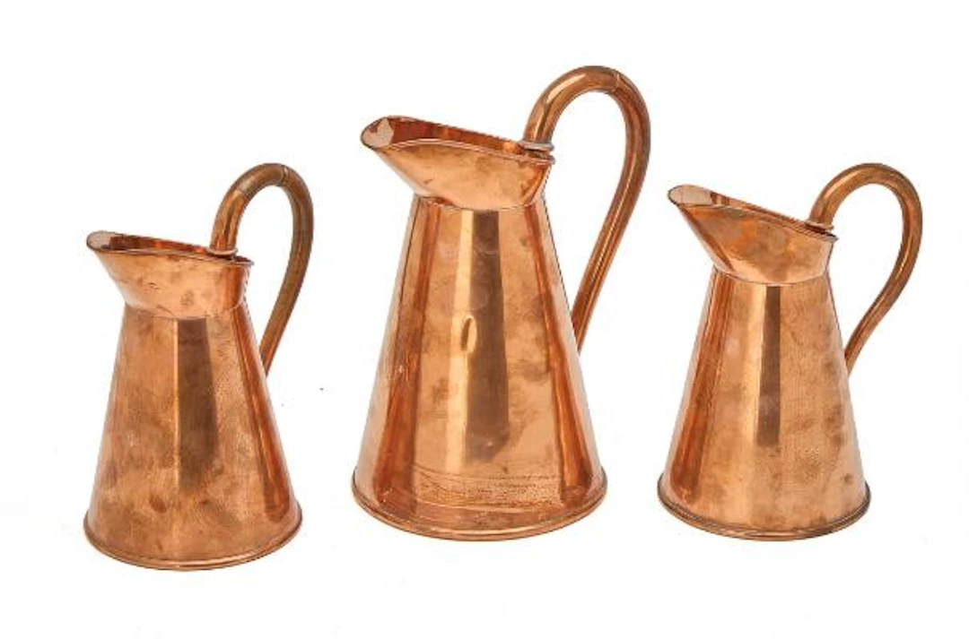 Three royal copper kitchen pitchers with owner's monogram for Christian