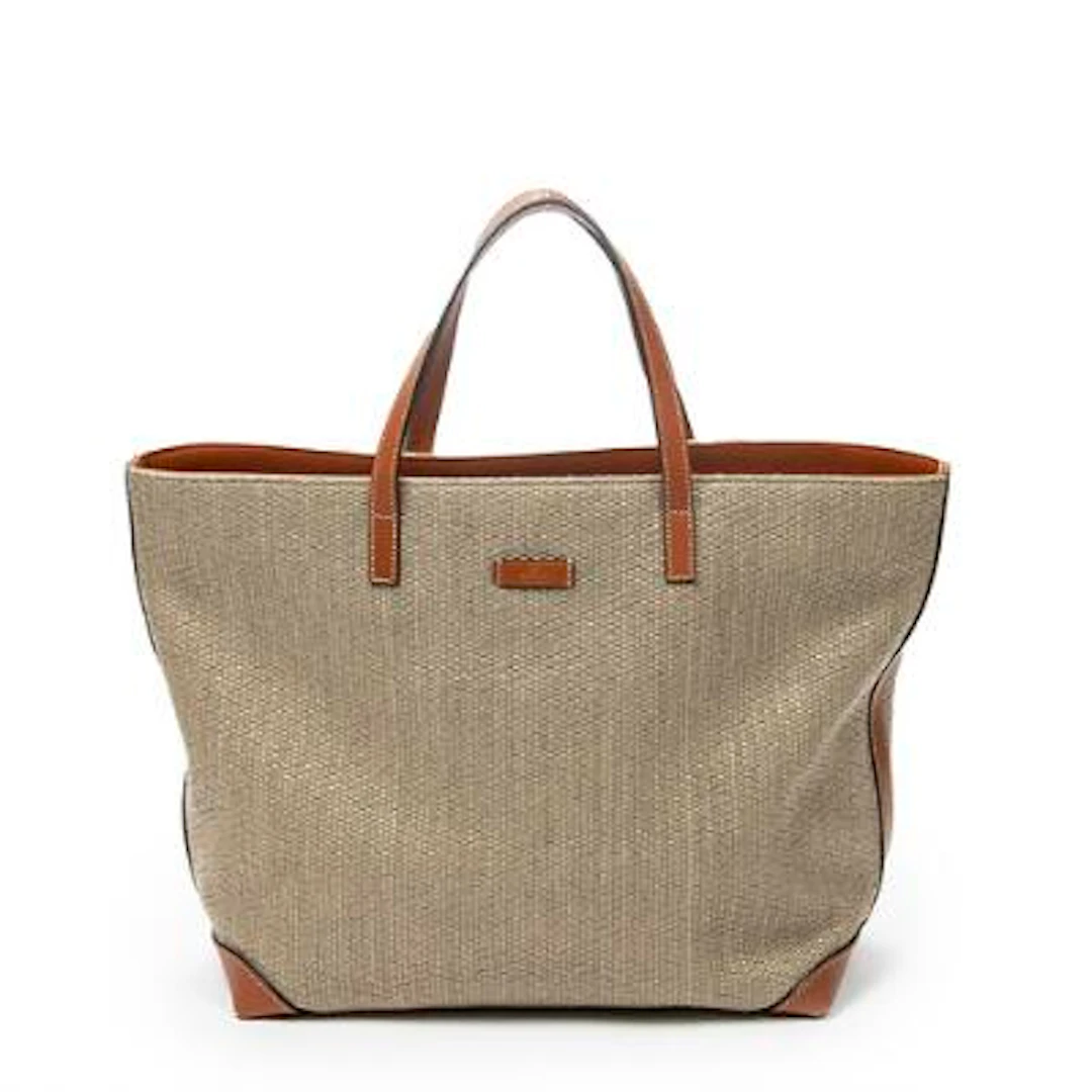 Gucci: A tote bag of light brown raffia canvas with brown leather