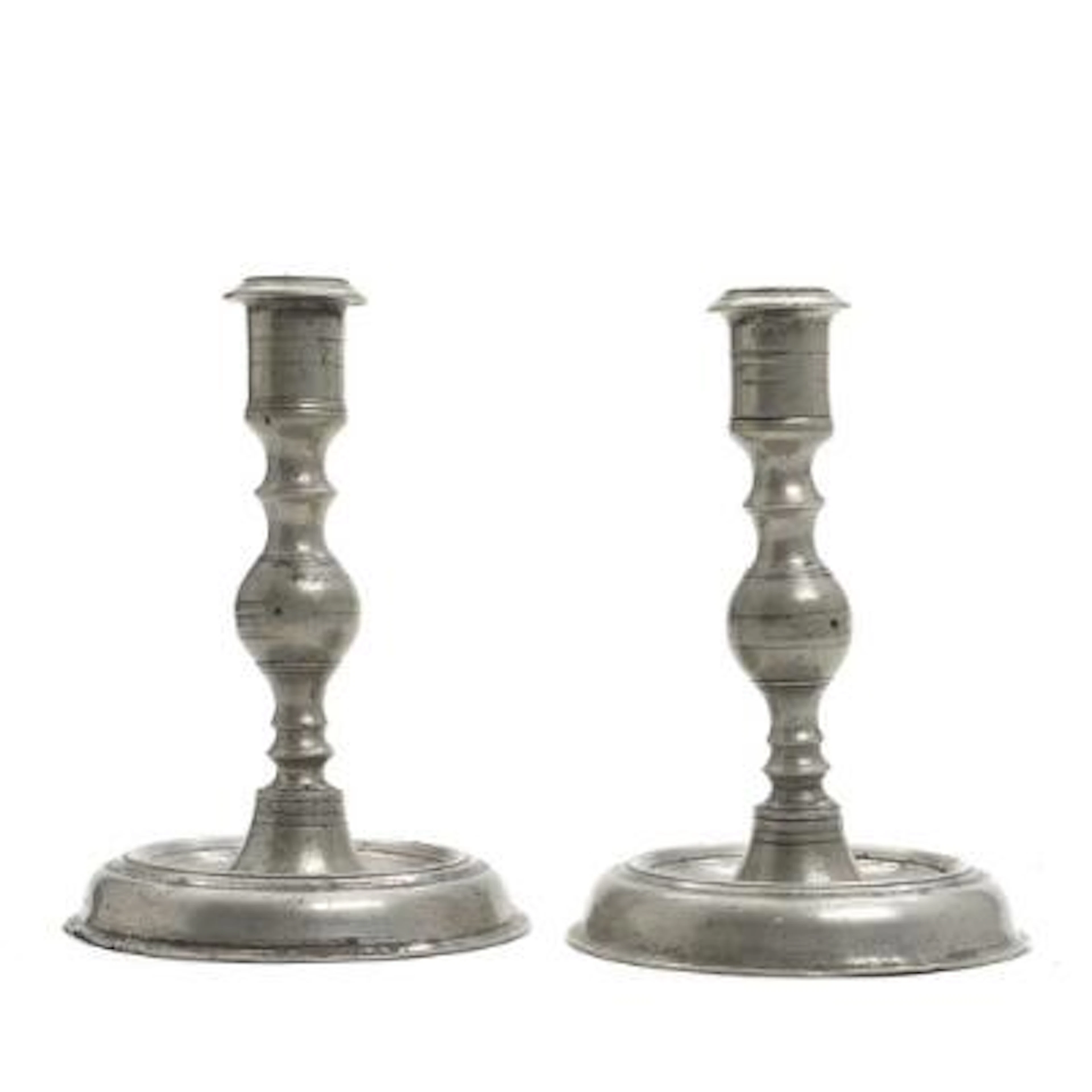 A pair of pewter candlesticks with baluster-form stems on circular