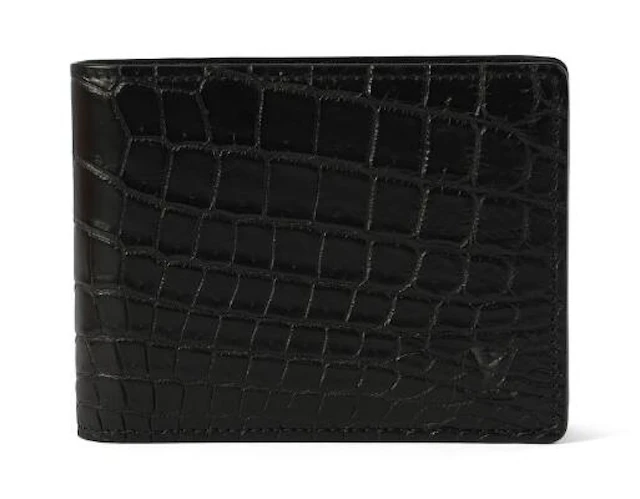 Louis Vuitton: A fold over wallet of black crocodile skin with five