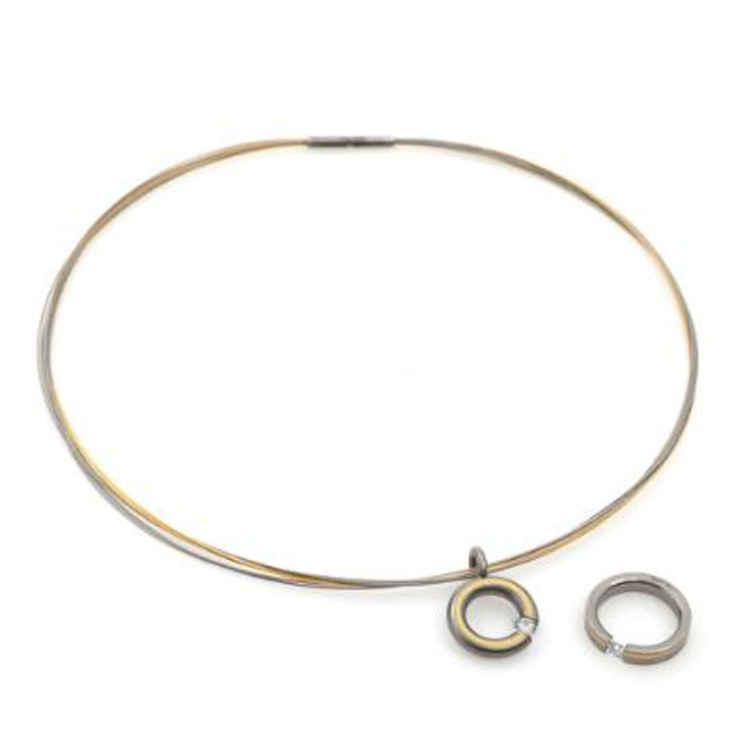 A necklace and ring set with faceted clear stones, mounted in titanium