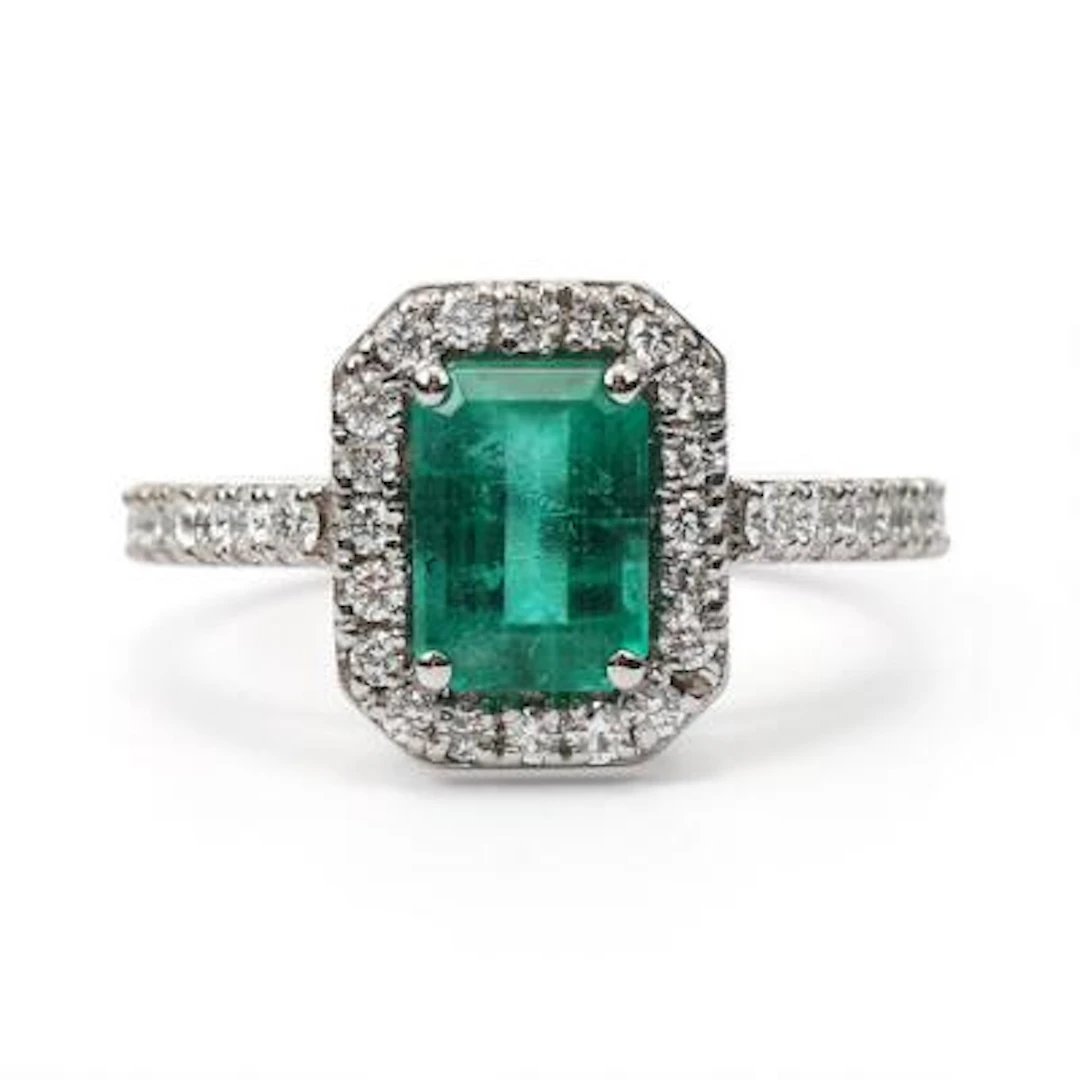 An emerald and diamond ring set with an emerald and diamonds, mounted