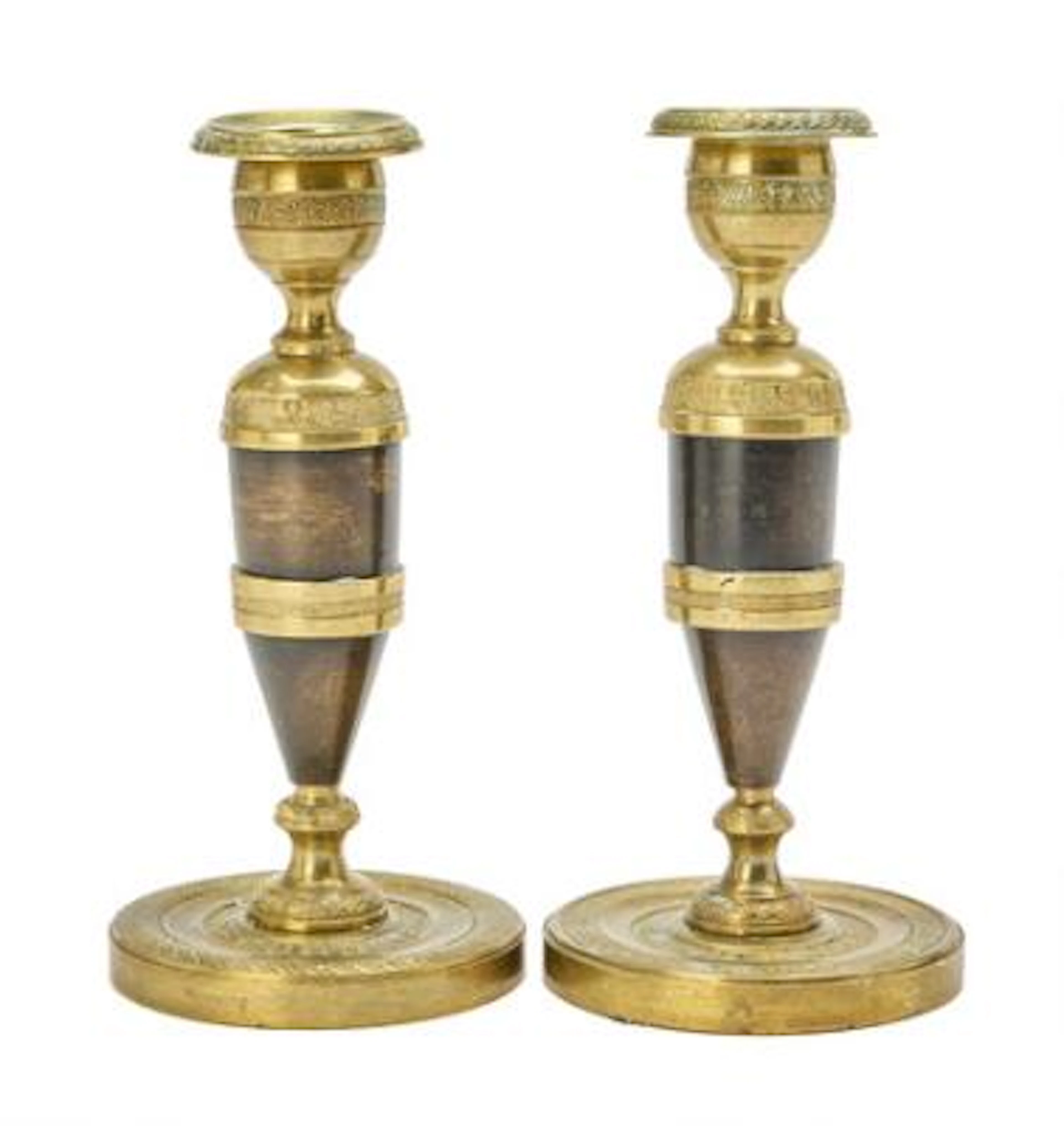 A pair of Empire style patinated and gilt bronze candlesticks, late