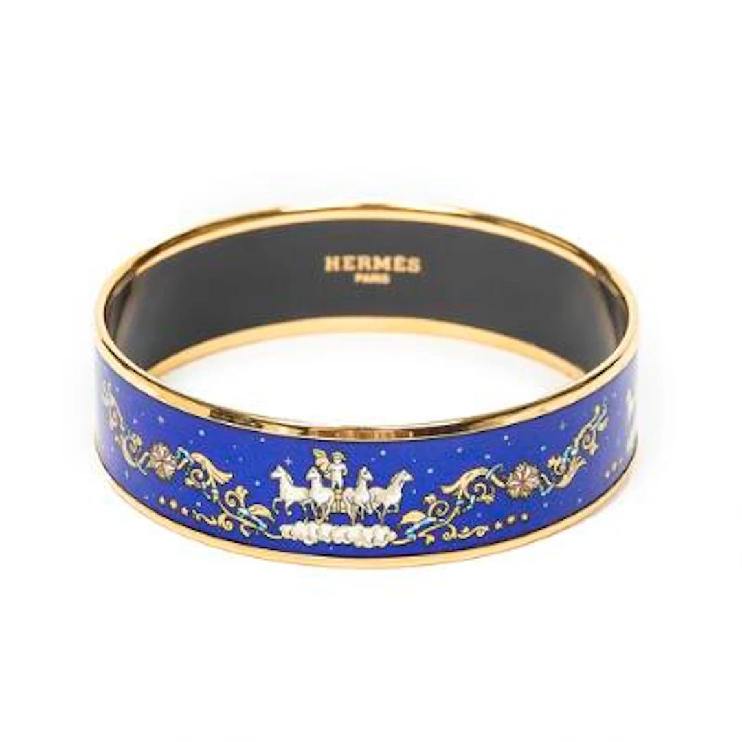 Hermès: A bangle set with a blue enamel motif mounted in gold coloured