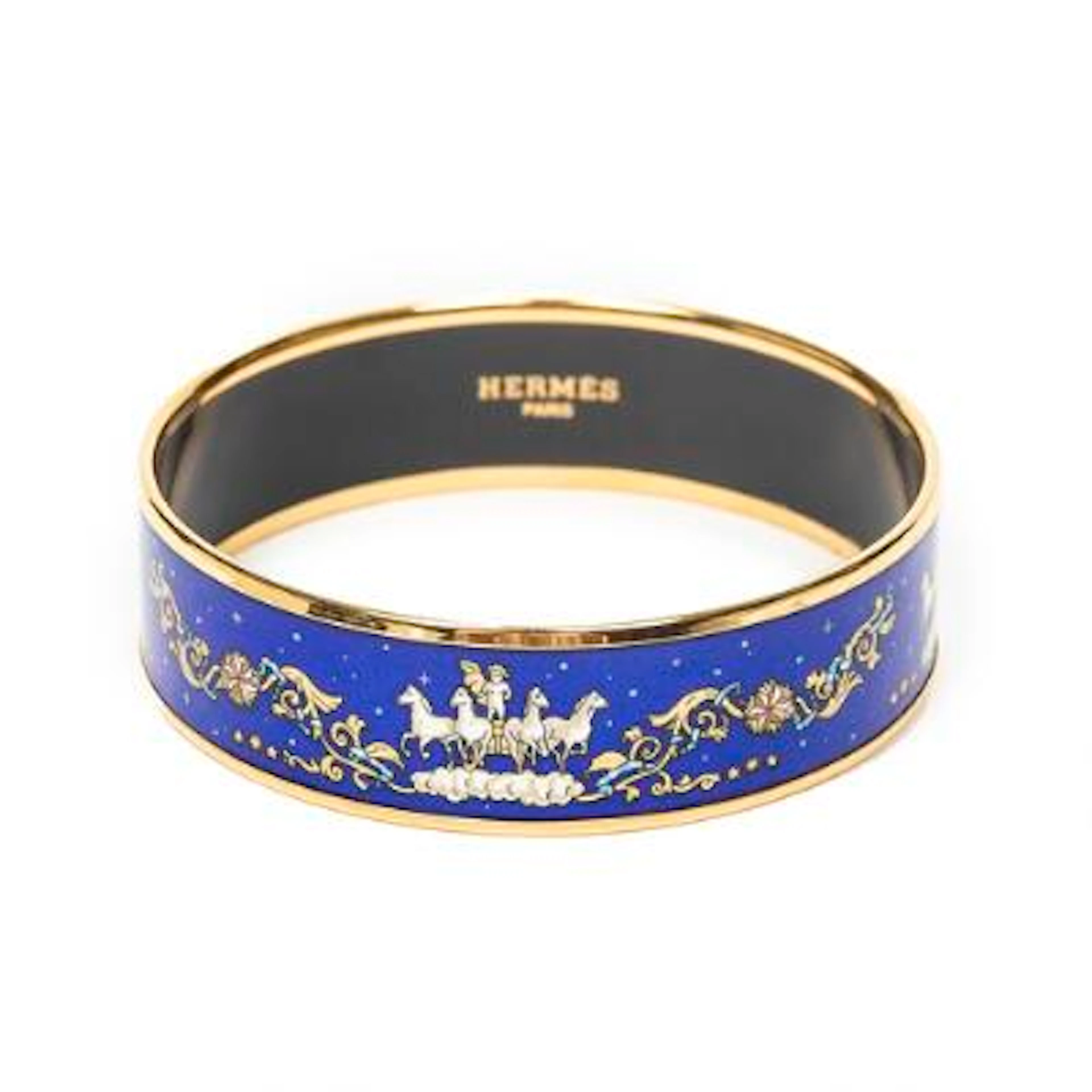 Hermès: A bangle set with a blue enamel motif mounted in gold coloured