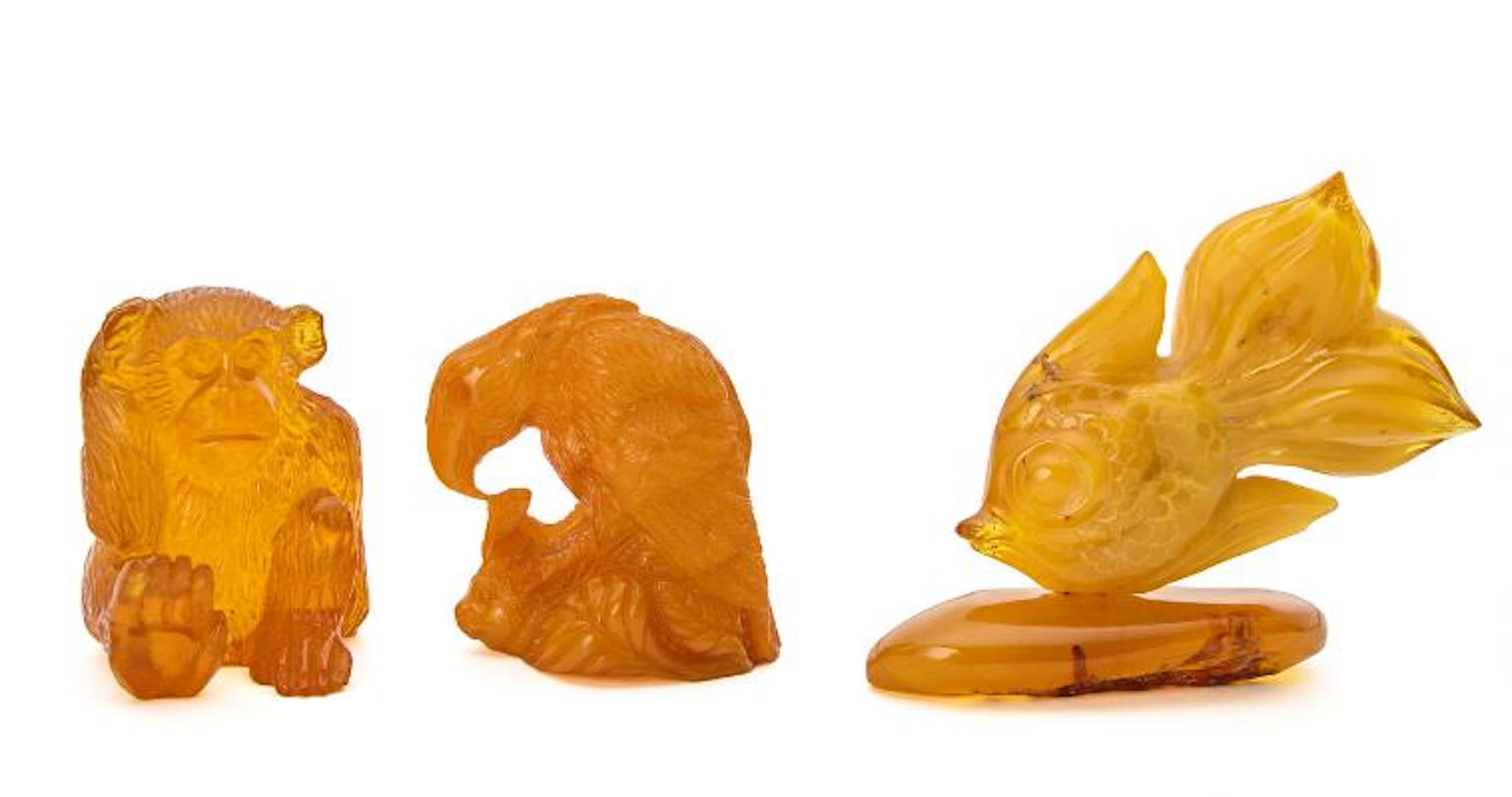 Three carved amber figures in the form of a carp, an eagle and a monkey.
