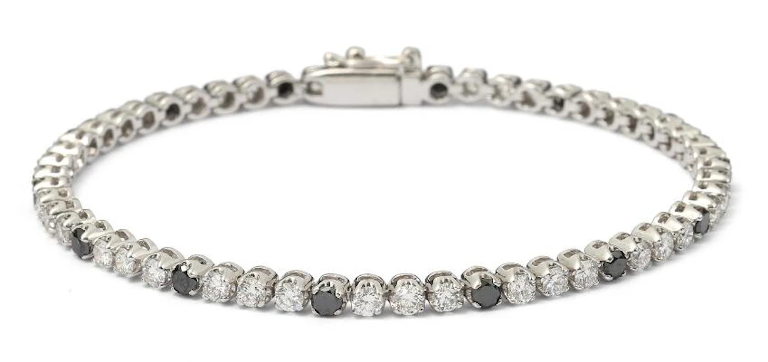 A diamond bracelet set with numerous black and white diamonds mounted