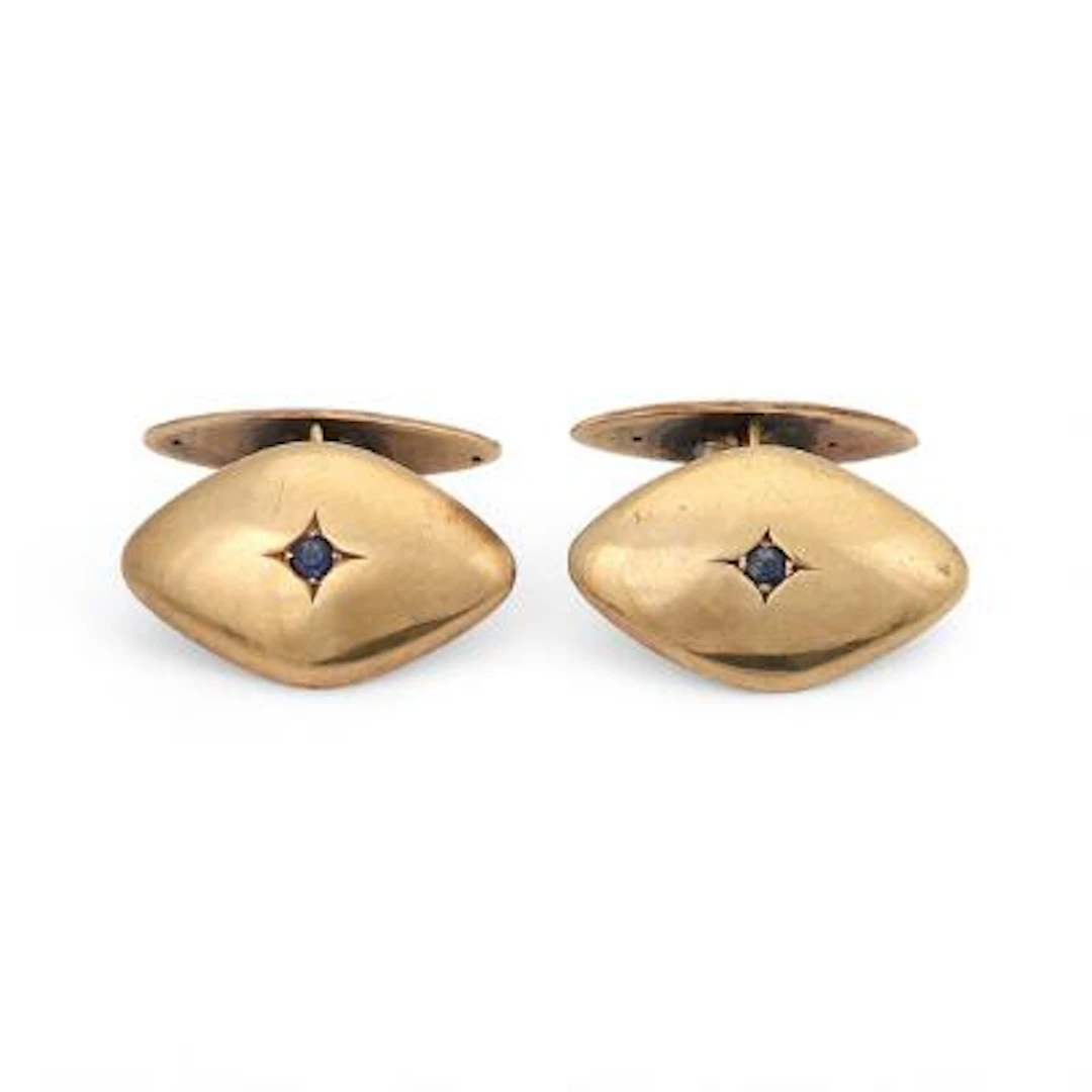 A pair of cufflinks set with a circular-cut syntetic sapphire, mounted