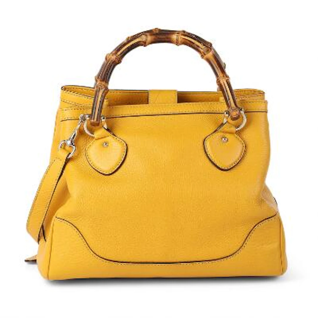 Gucci: A bag of yellow leather with gold tone hardware, two bamboo