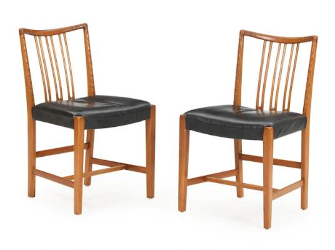 Hans J. Wegner: A pair of oak chairs with carvings, seats with patinated