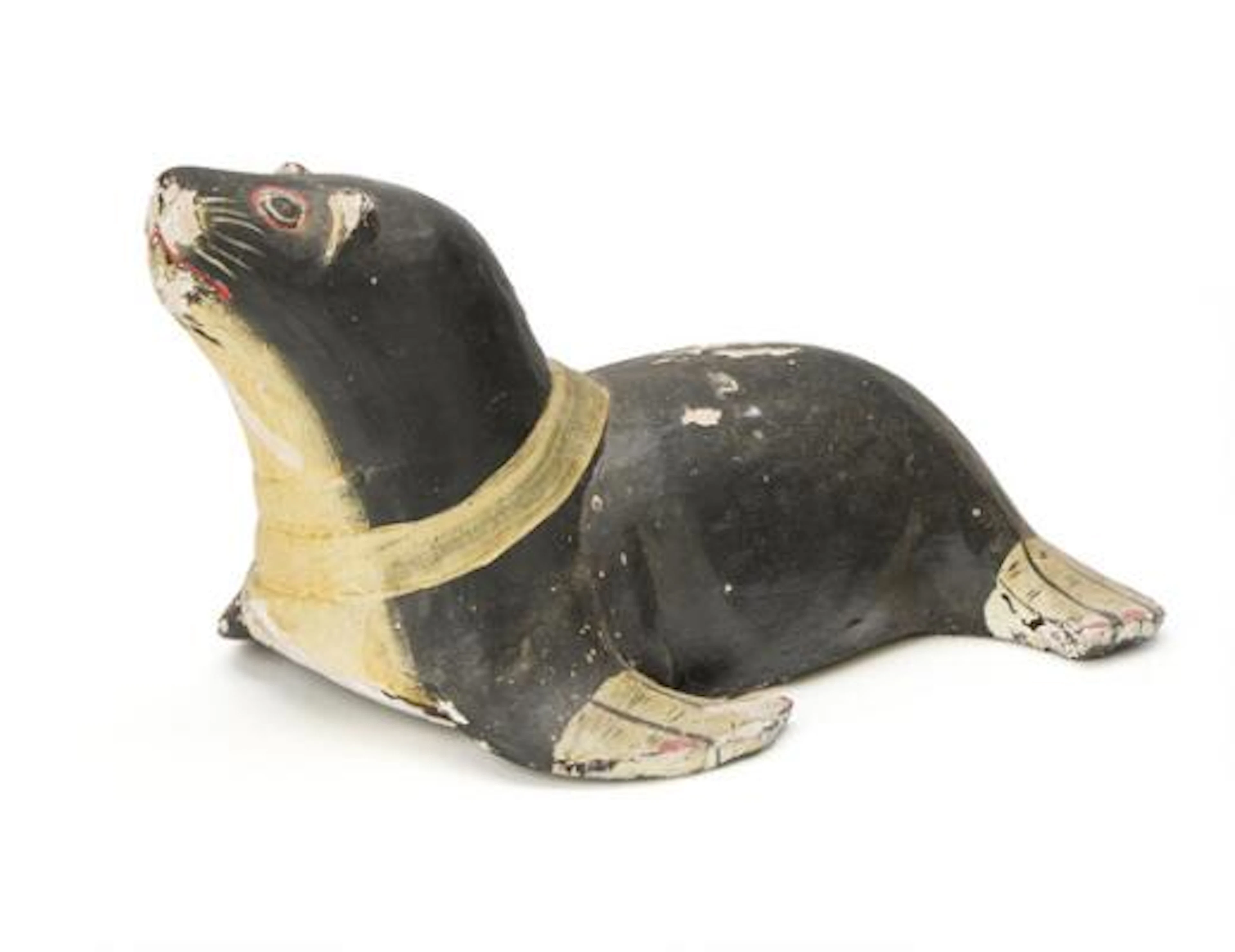 A painted wood decoy in shape of a seal, probably first half 20th