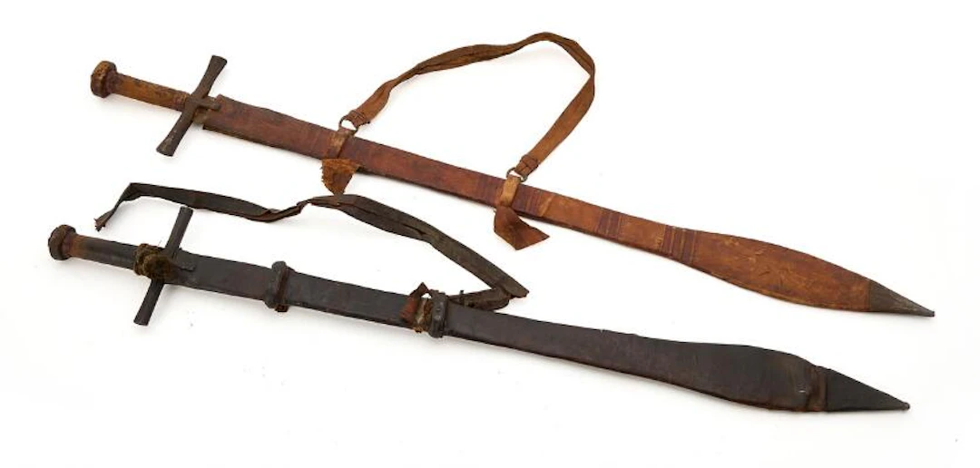 Two Sudanese Kaskara swords in typical scabbards, likely dating to