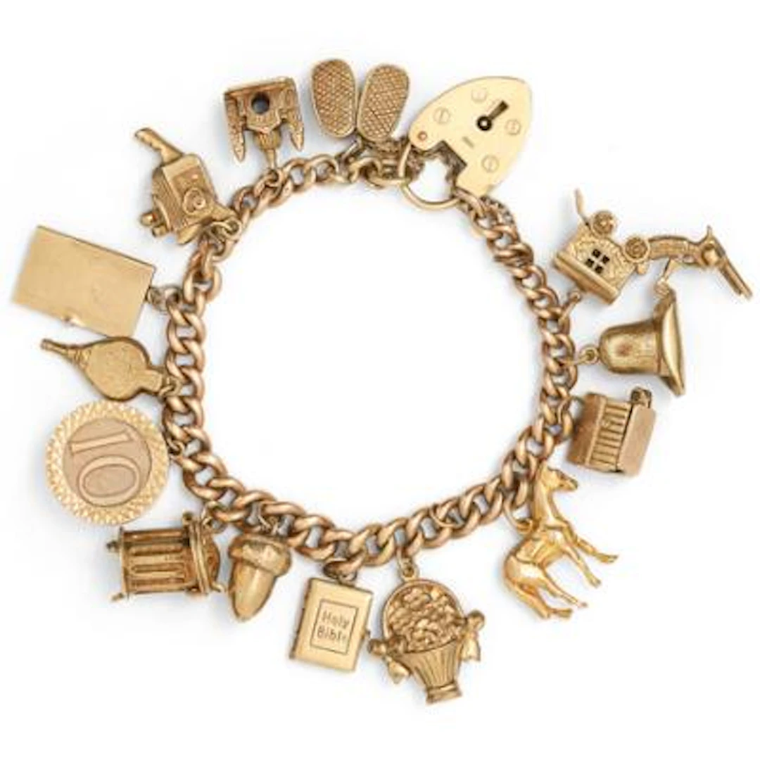 A charms bracelet set with numerous charms, mounted in 9k gold. L.