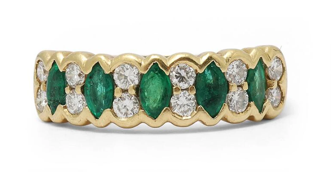 An emerald and diamond ring set with numerous emeralds and diamonds