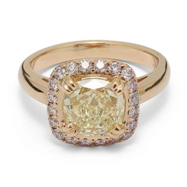 A diamond ring set with a cushion-cut yellow diamond encircled by