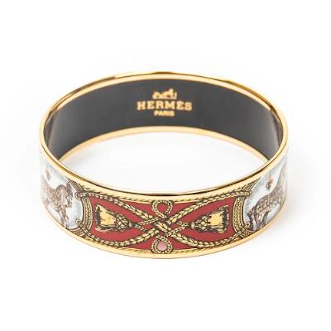 Hermès: A bangle set with enamel motif, mounted in gold coloured metal.