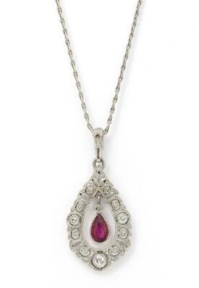 A ruby and diamond pendant set with a ruby and numerous diamonds