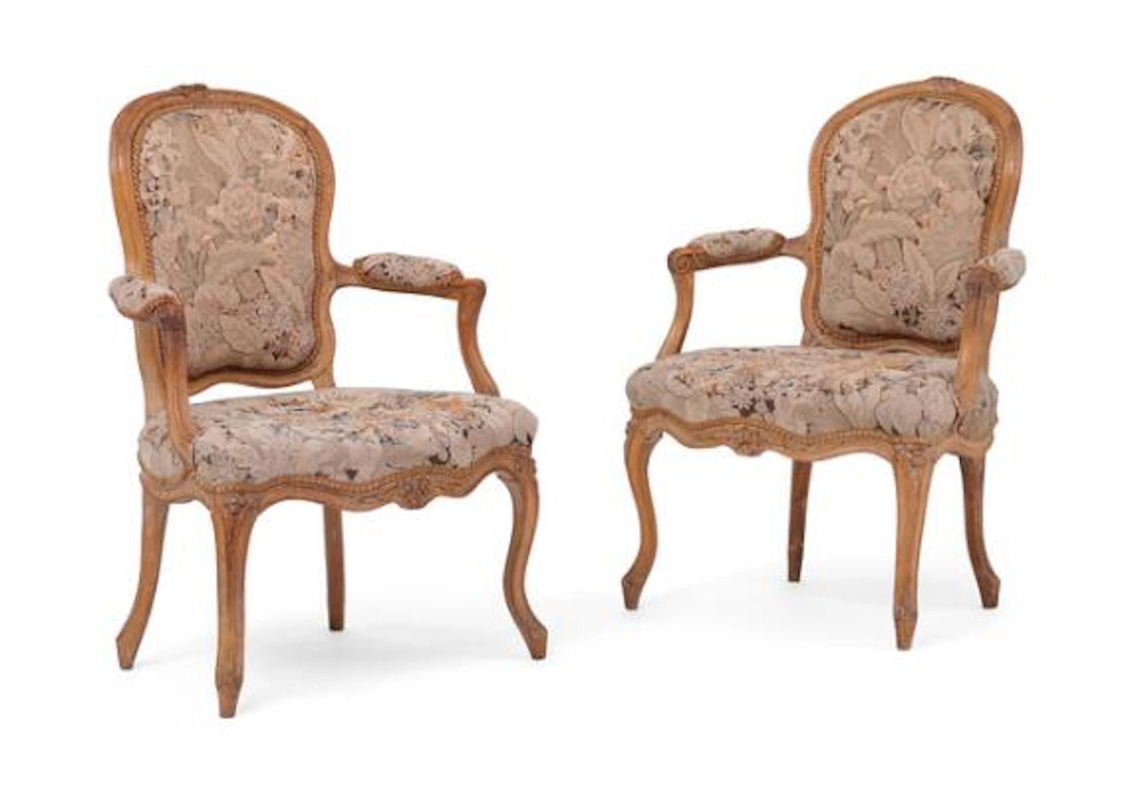A pair of Rococo armchairs, richly carved with flowers and foliage.