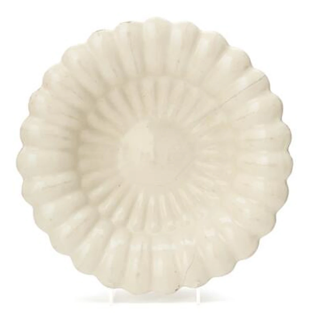 A gadrooned Delft faience dish. 18th century. Diam. 29.5 cm. Formerly