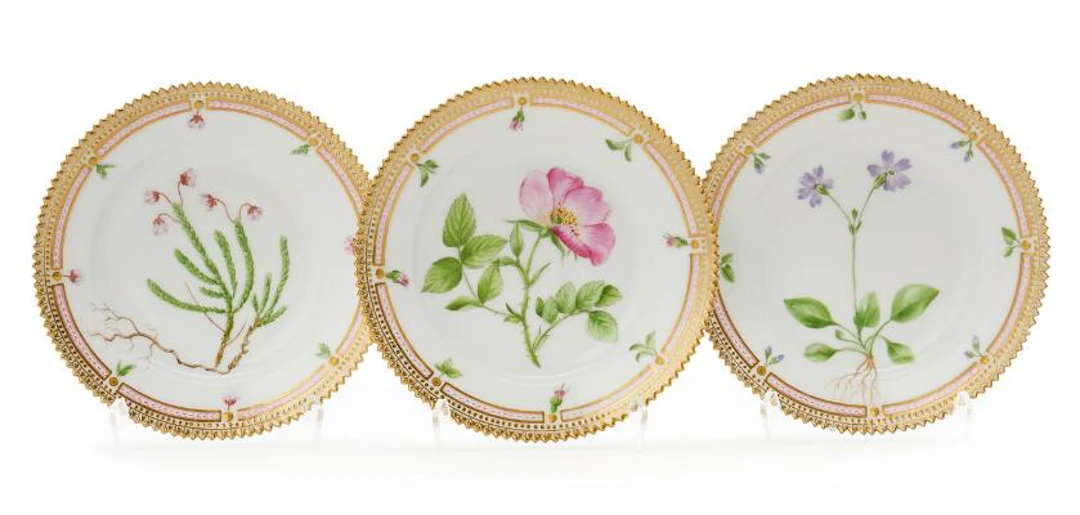 Three "Flora Danica" enamelled and gilt porcelain side plates. Royal