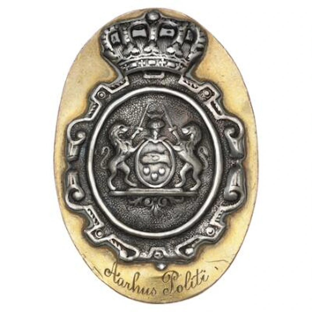 Oval brass police badge from the Aarhus Police featuring a crowned