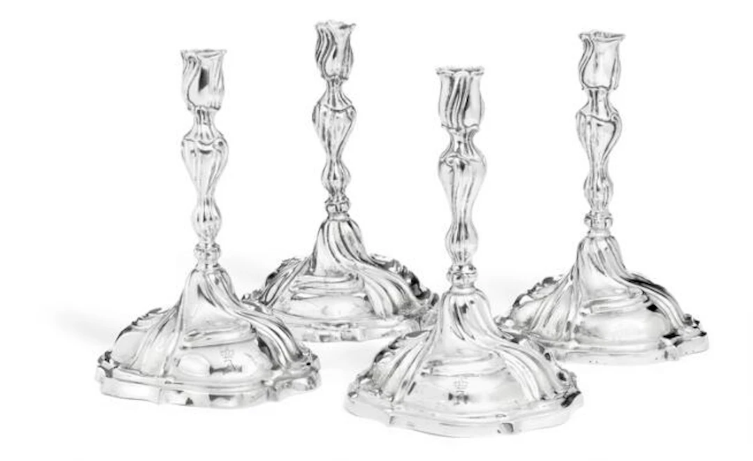 A set of four uniform Augsburg Rococo embossed silver candlesticks.