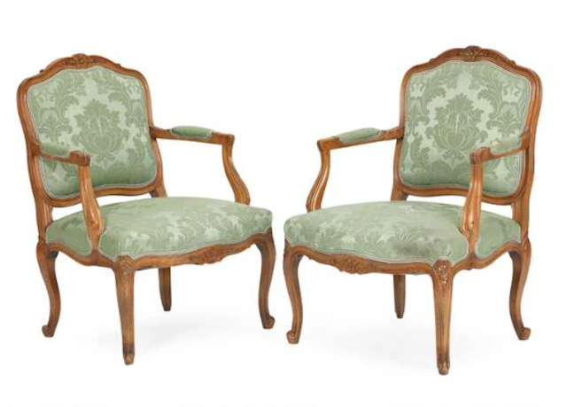 A pair of walnut armchairs, upholstered with green furniture fabric.